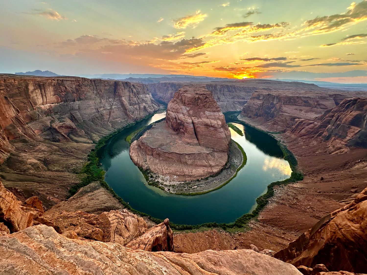 Aerial view of Horseshoe Bend canyon with Colorado River at golden sunset.