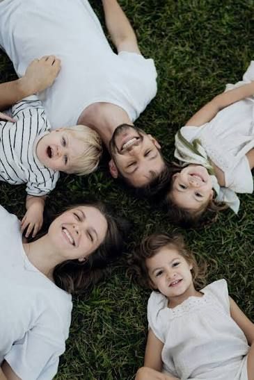 A family lying in a circle in a field