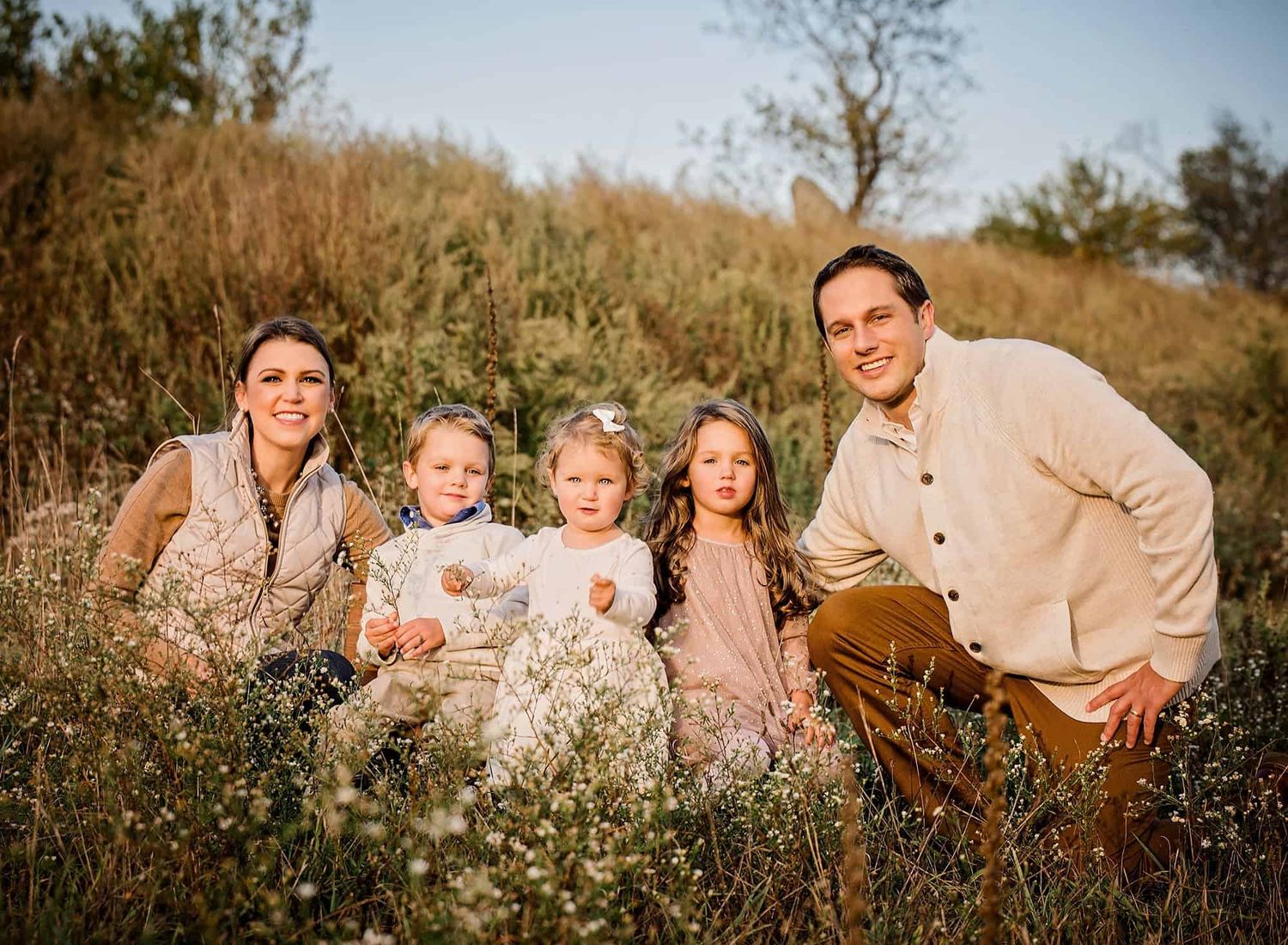 Mom, Dad and 3 children sitting in a field