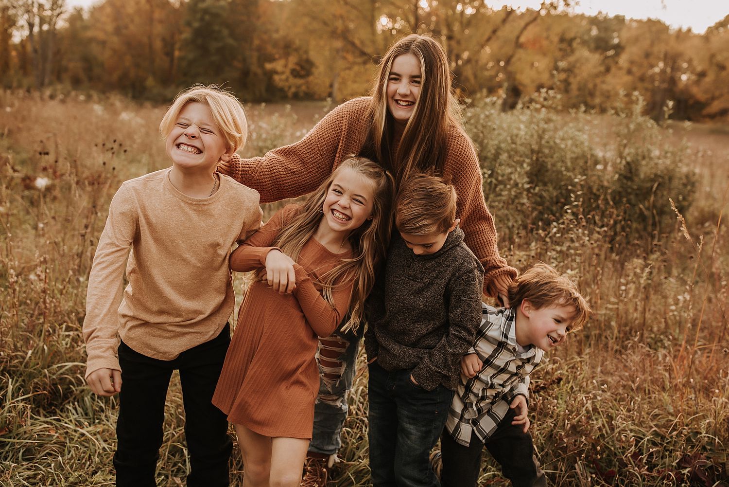 Children in a field at sunset laughing