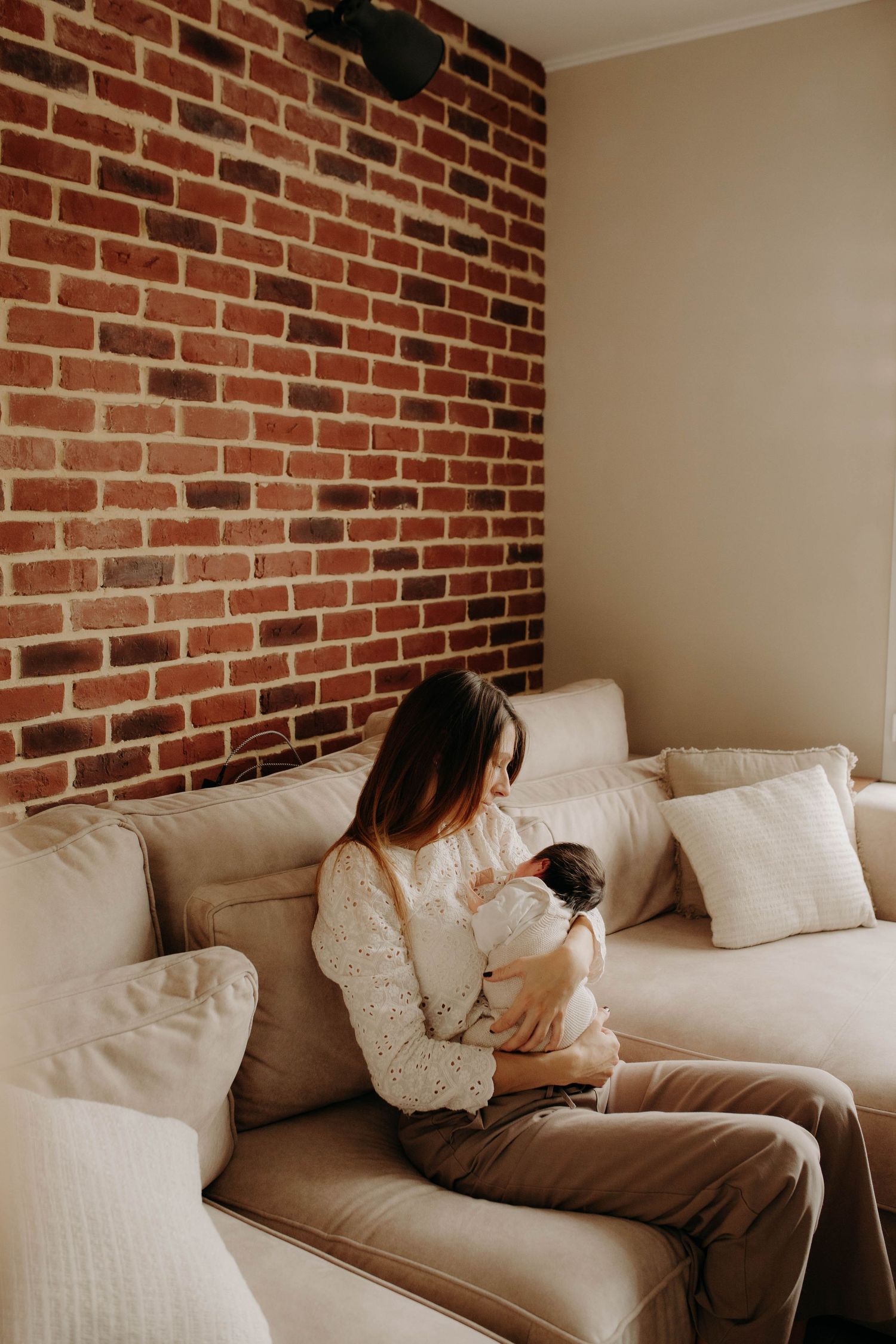 bébé + maman assis dans canapé