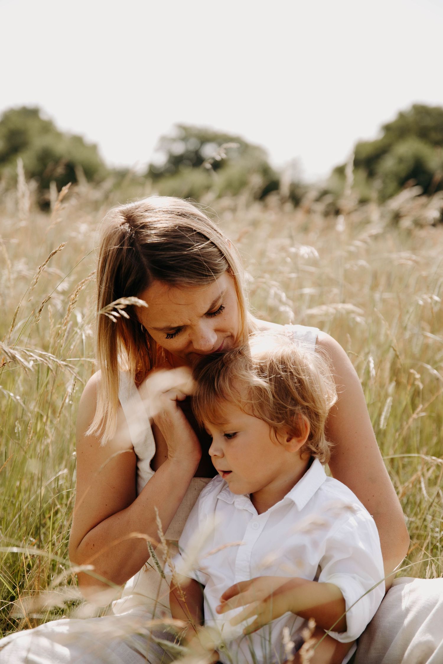 une maman et son fils qui jouent, dans l'herbe
