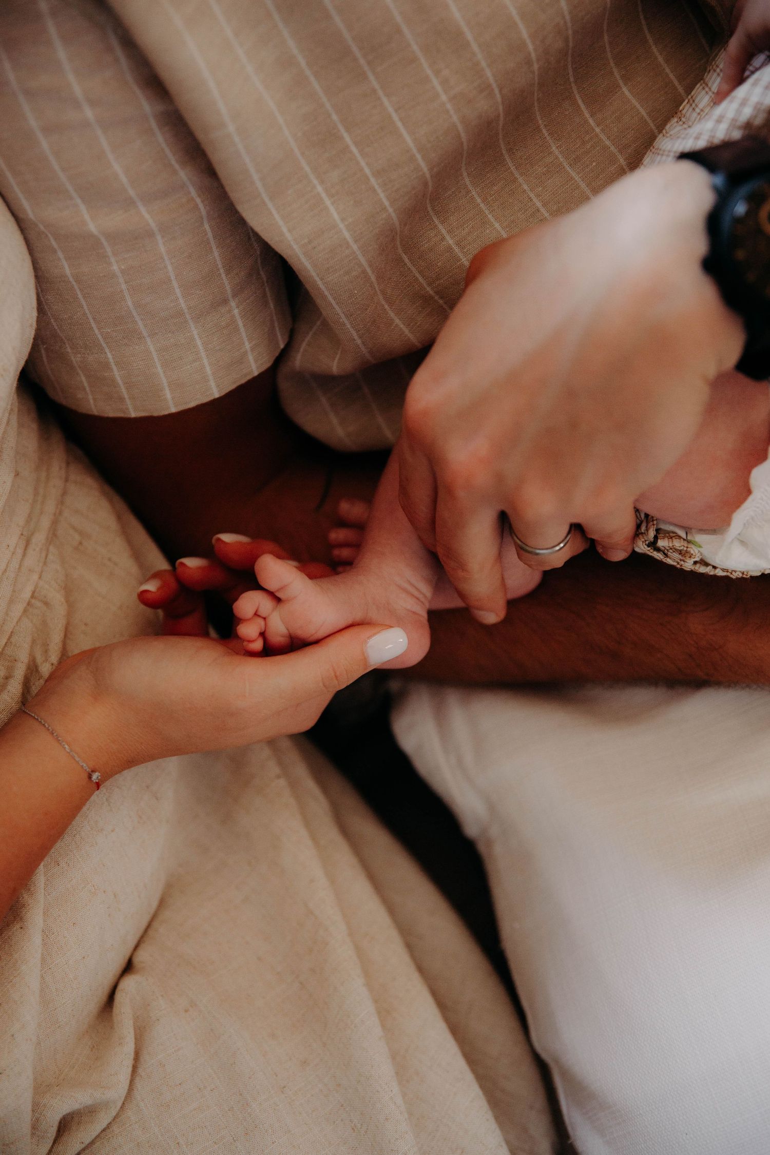 mains de parent avec celle de leur bébé