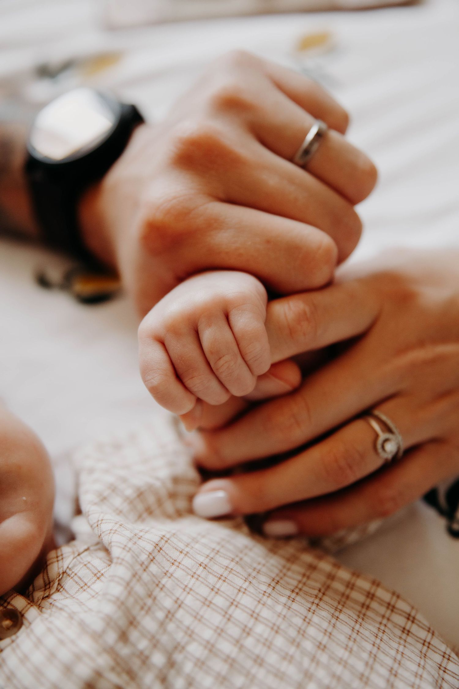 mains de parent avec celle de leur bébé