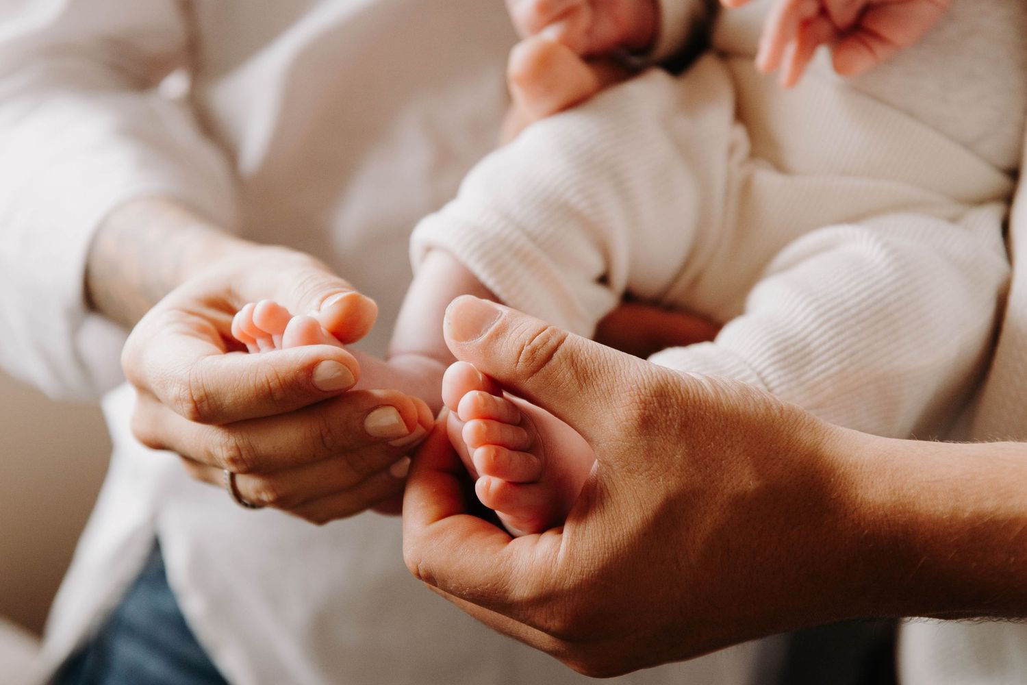 pied de bébé dans main de maman