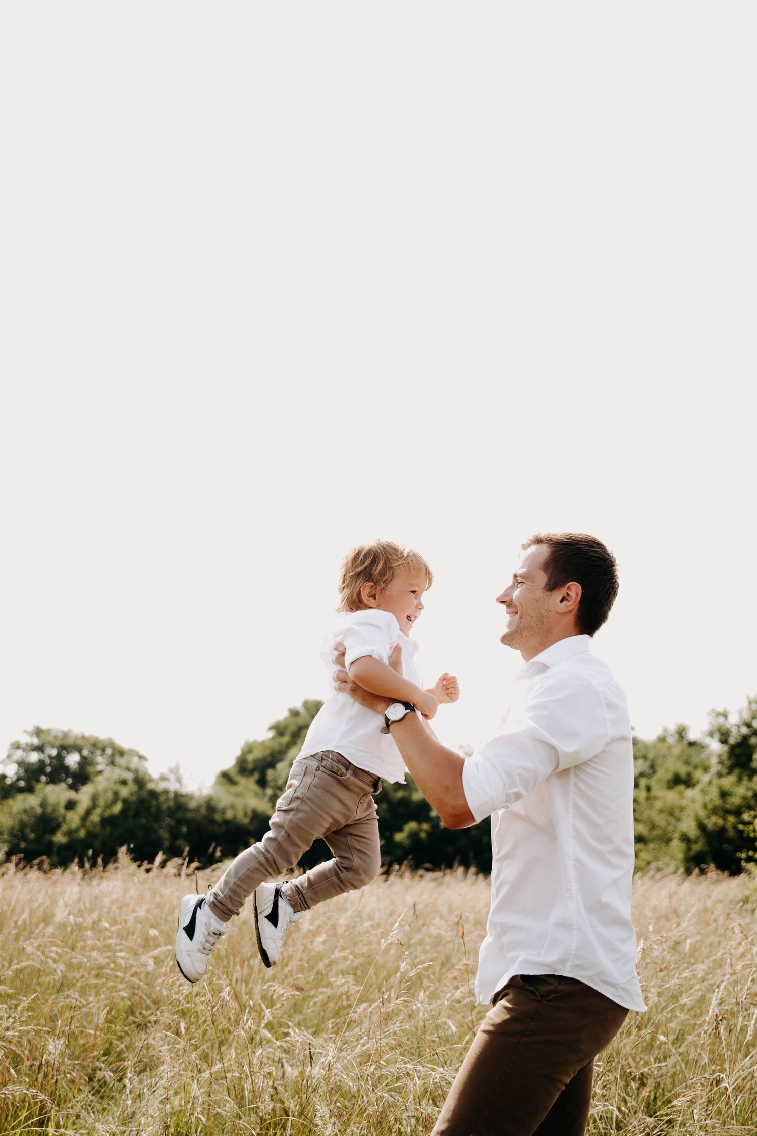 un papa qui jette son fils en l'air pour le faire rire