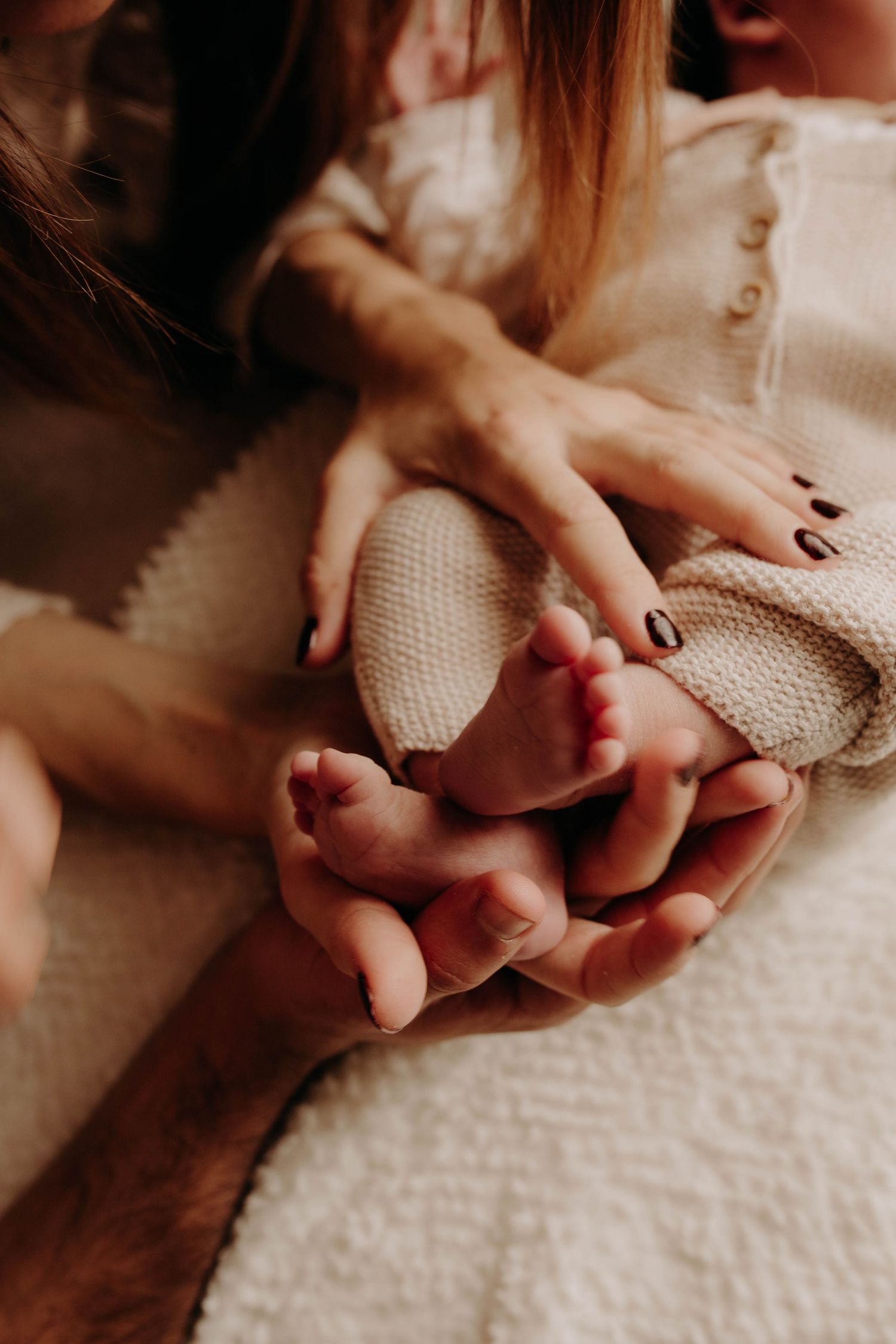 pieds de bébé dans les mains de ses parents