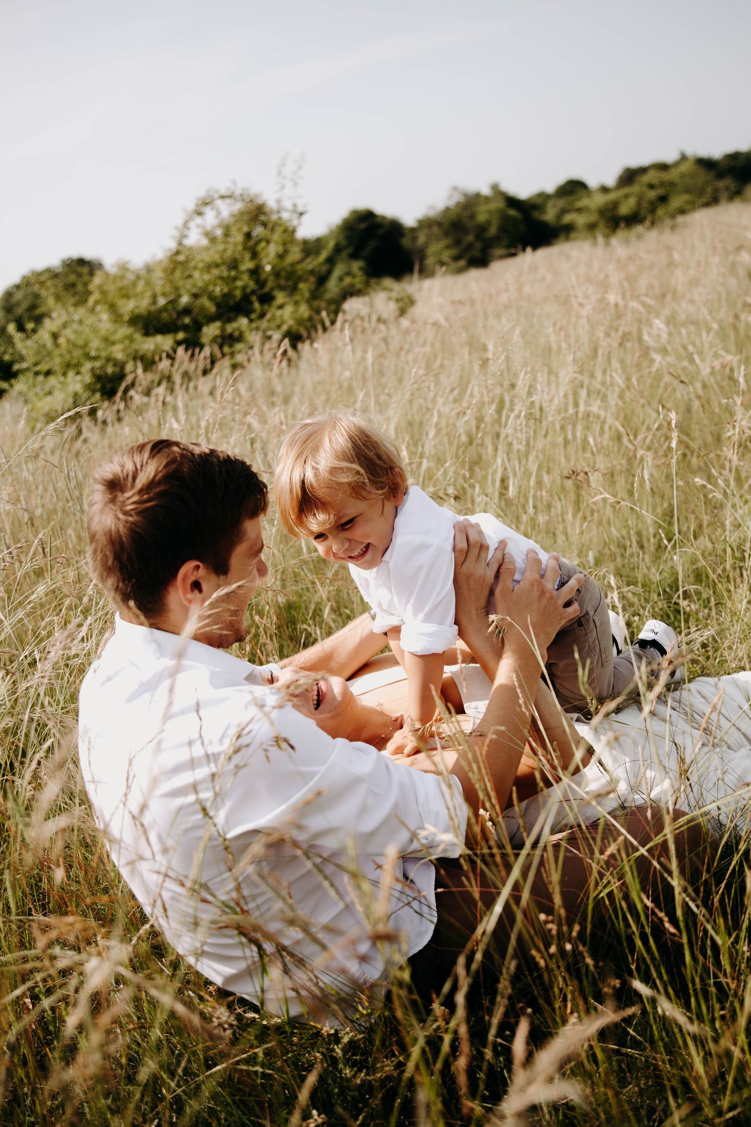 un papa et son fils qui jouent, dans l'herbe