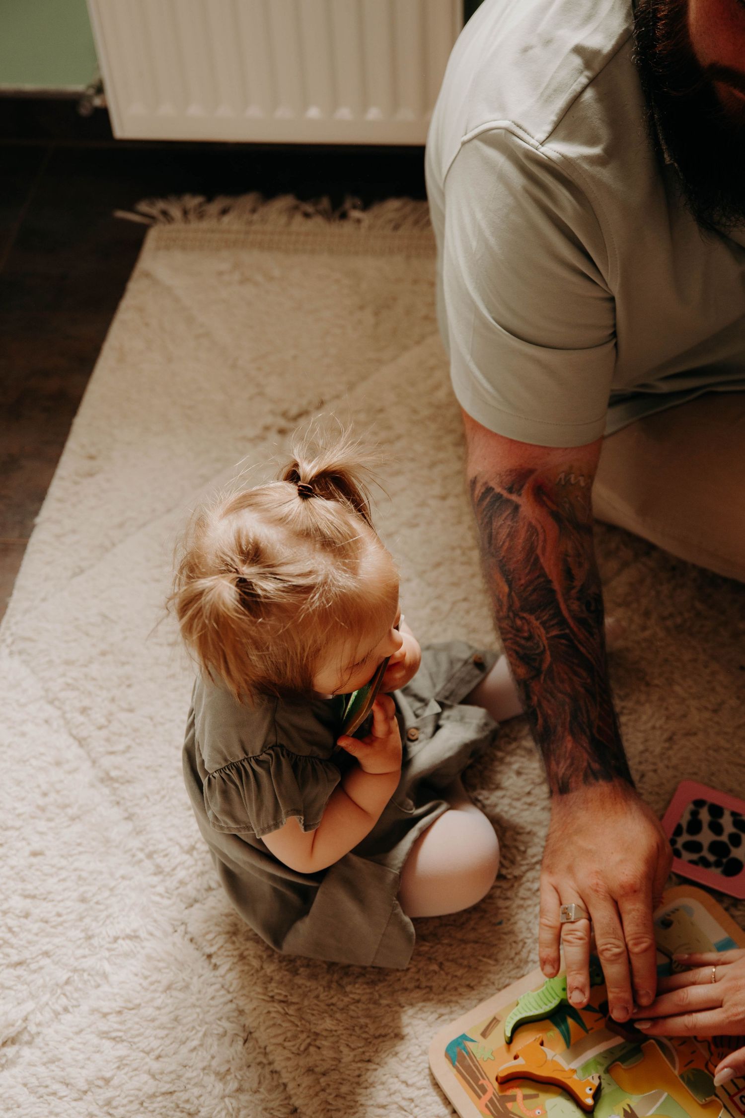 petite fille assise au sol qui joue avec son papa