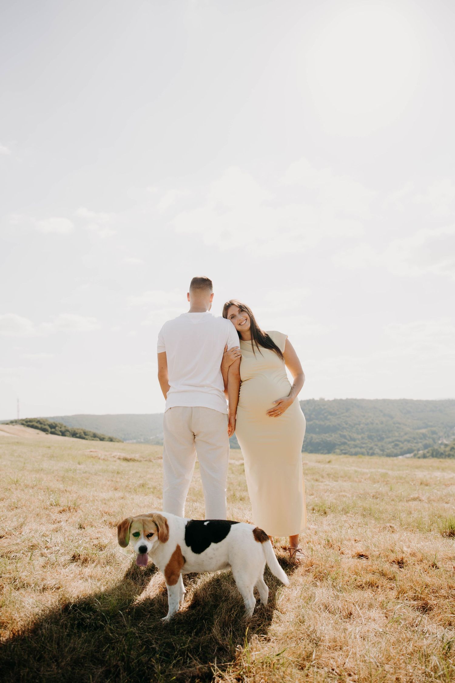 couple dont femme enceinte jouant avec chien