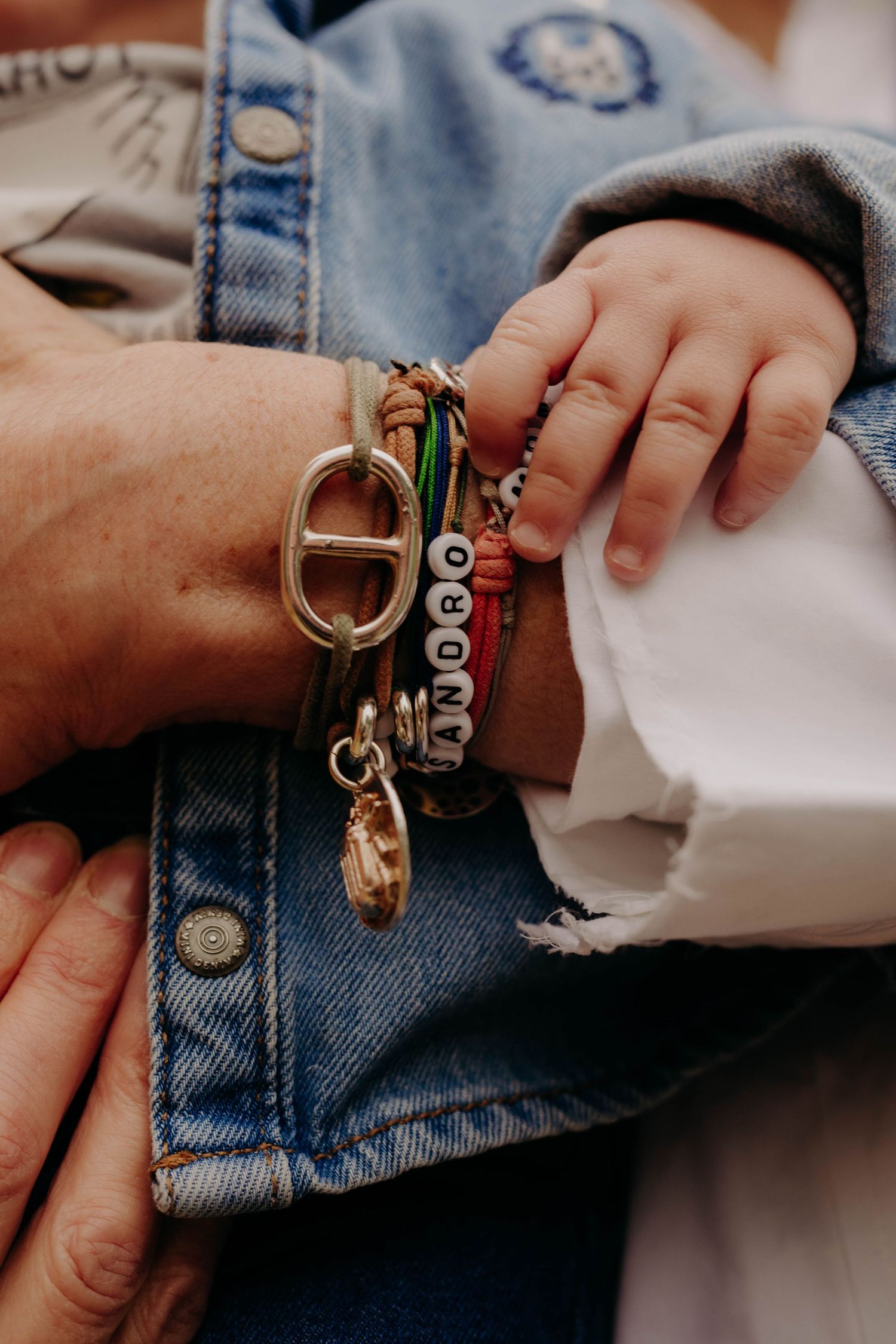 bras d'une maman avec les bracelets au nom de ses enfants