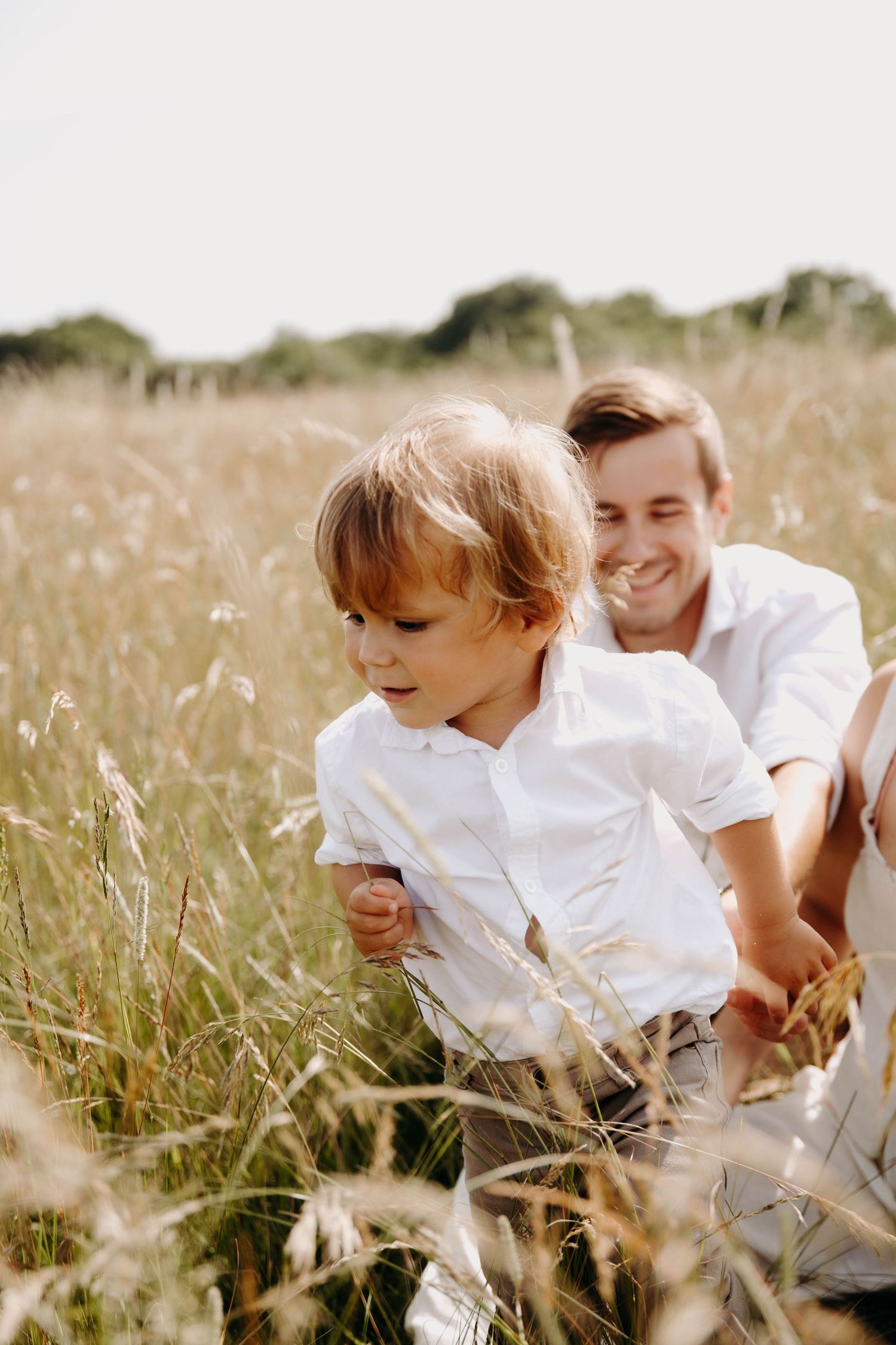 un papa et son fils qui jouent, dans l'herbe