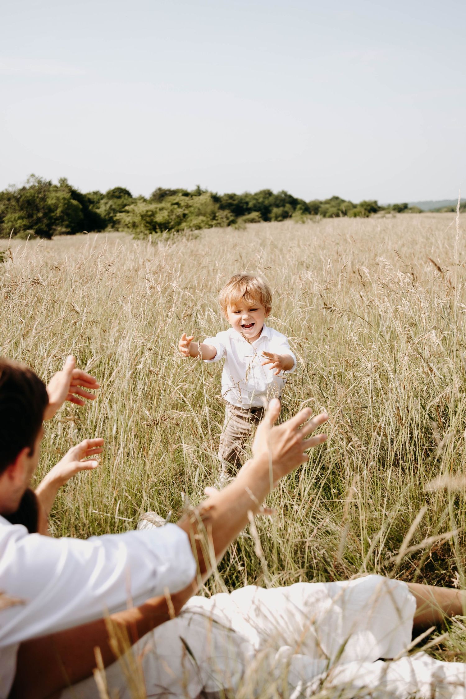 un papa et son fils qui jouent, dans l'herbe