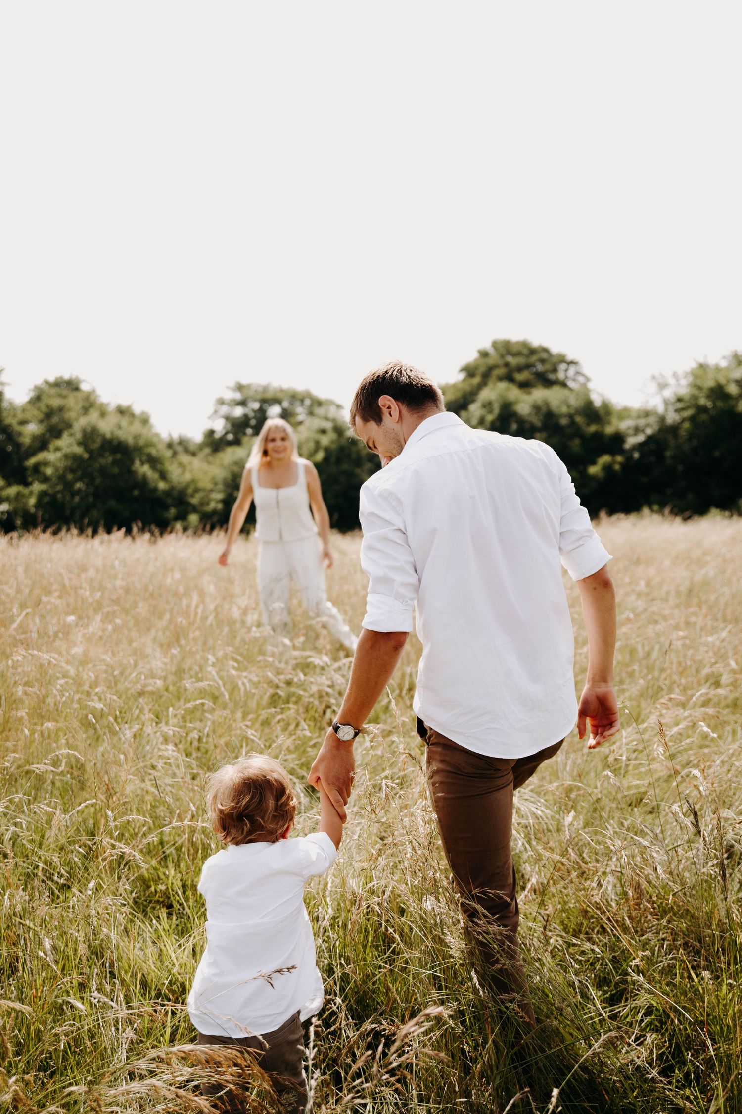 un papa et son fils de dos qui se dirigent vers la maman face a la photo