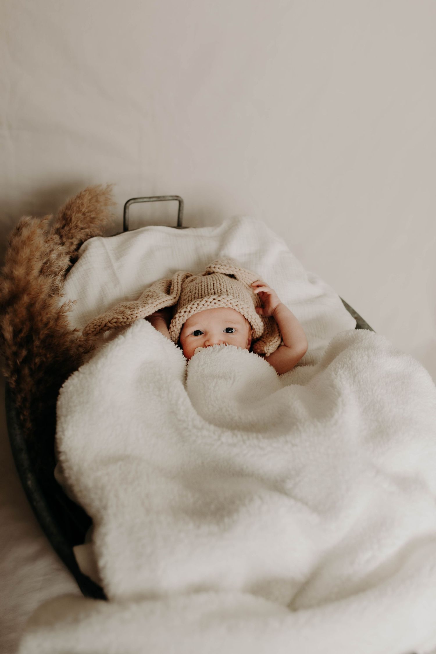 bébé dans un panier caché par une couverture a mi-visage