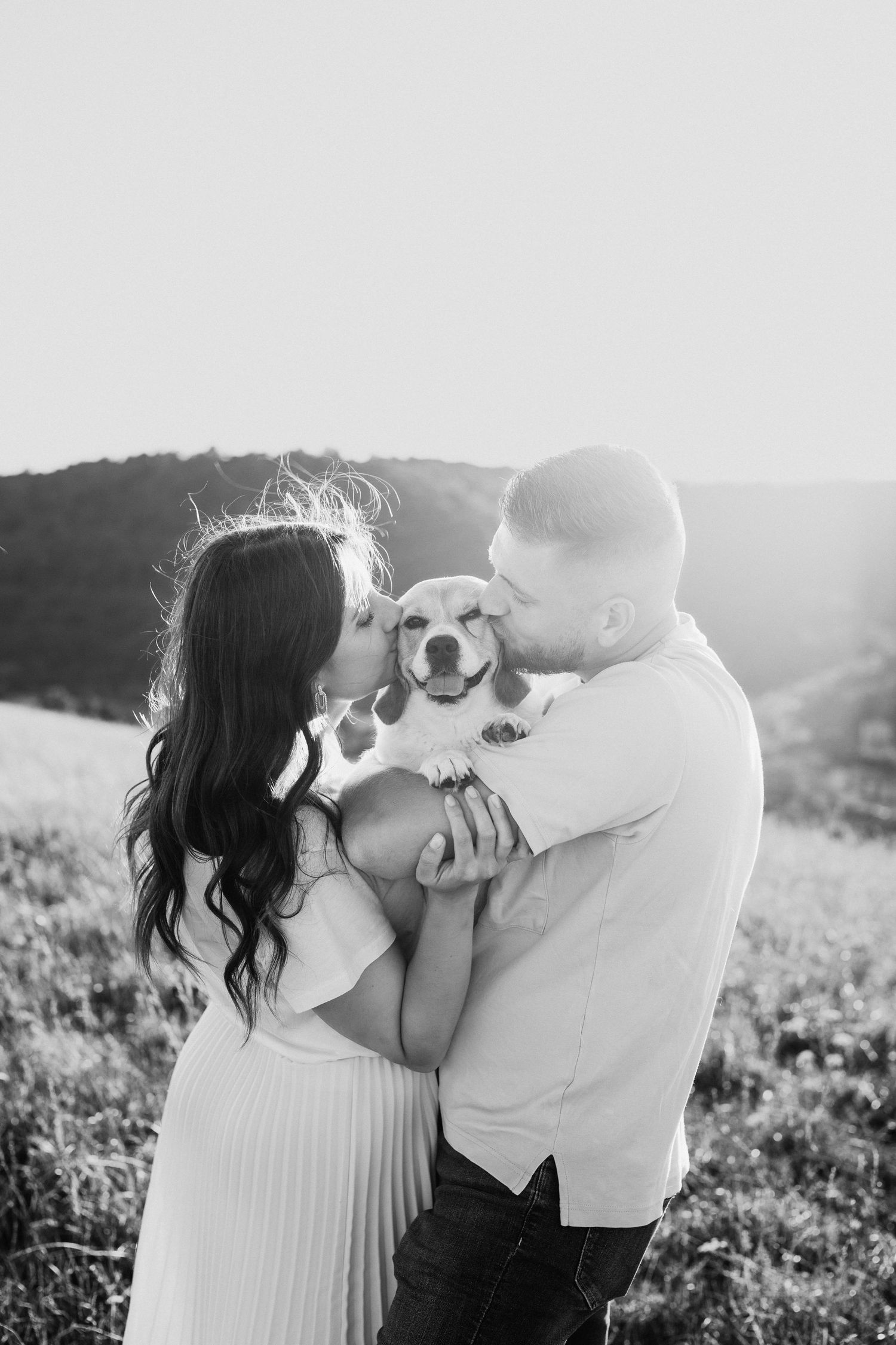couple qui s'enlace avec leur chien