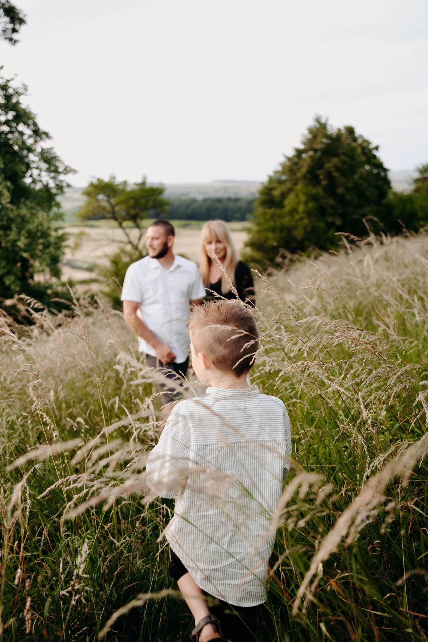 couple de parents avec leur enfant, l'enfant est de dos et se dirige vers ses parents