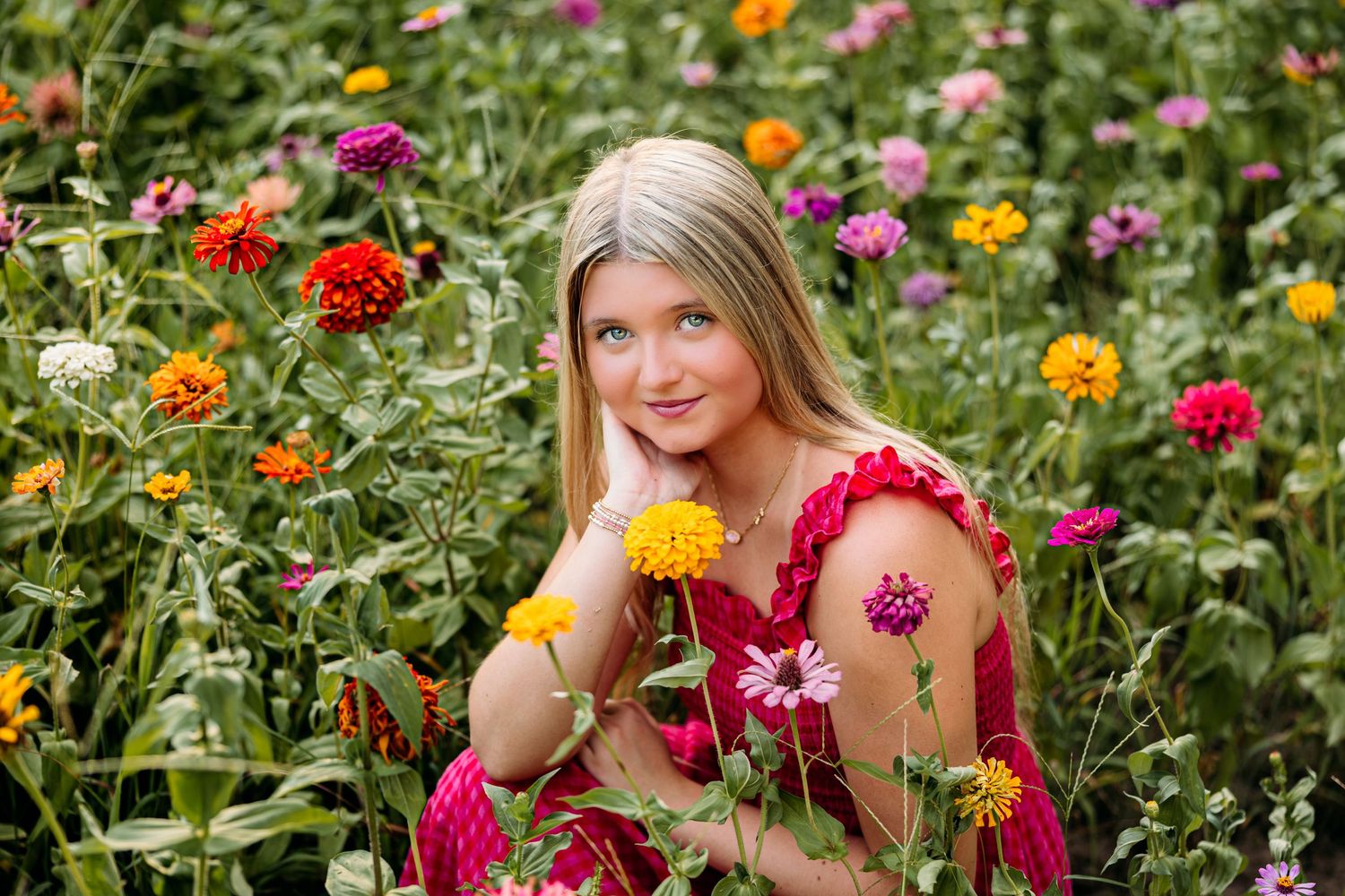 Senior photoshoot in a field of zinnias with photographer located throughout the Kansas City Metro area. Based in Blue Springs, Missouri.