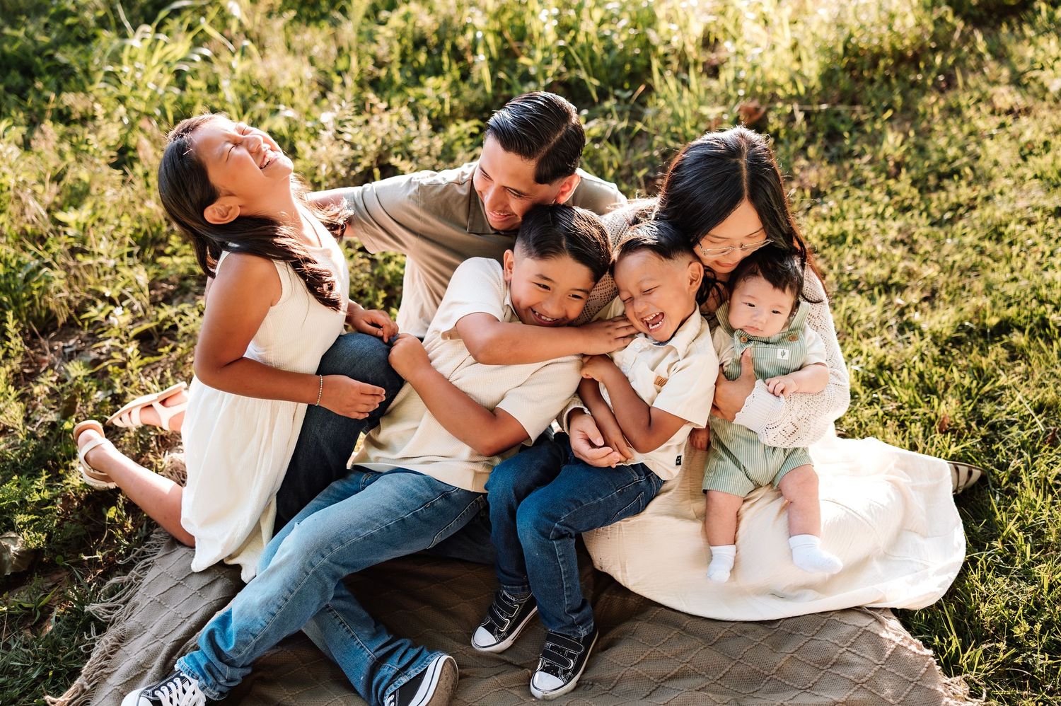 Family photoshoot in tall grass with photographer located throughout the Kansas City Metro area. Based in Blue Springs, Missouri.