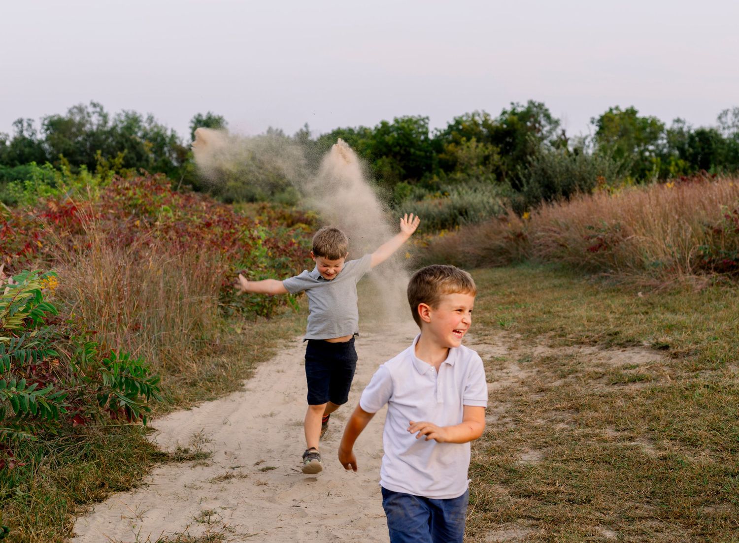 Boys throwing dirt photoshoot with photographer located throughout the Kansas City Metro area. Based in Blue Springs, Missouri.