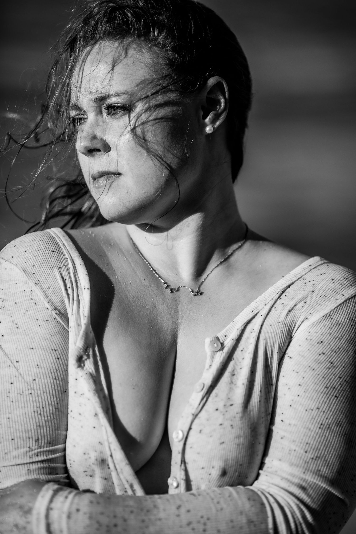 Black and white close-up of a woman with wet hair and low-cut top in dramatic outdoor lighting Cape cod beach Boudoir photos