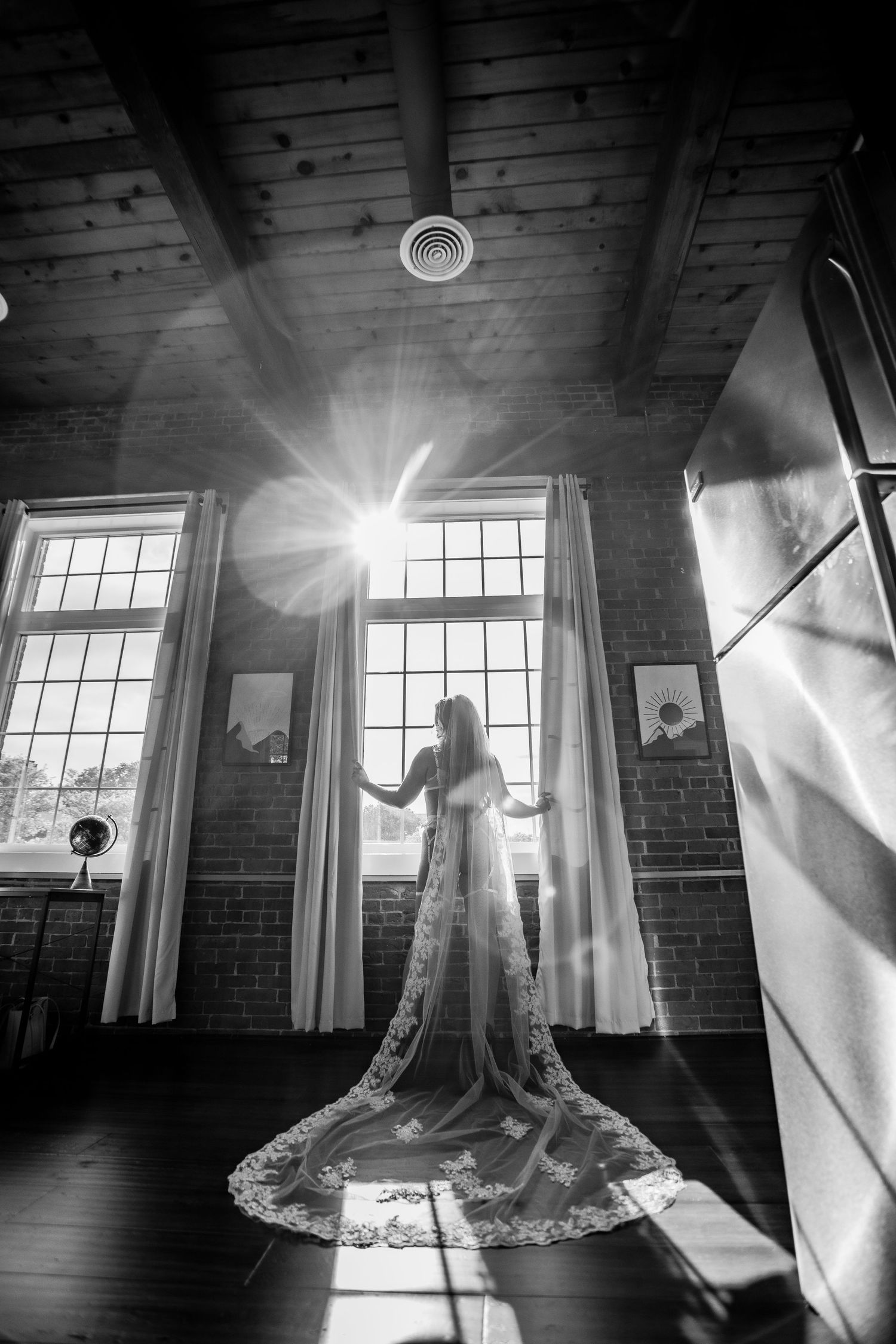 Black and white silhouette of bride in lingerie and long lace veil backlit by studio windows Cape cod studio bridal Boudoir photos