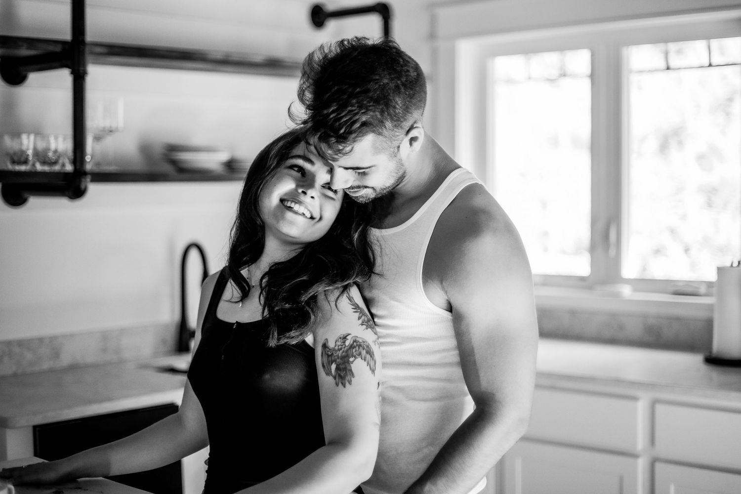 Black and white photo of a couple embracing intimately in a cozy kitchen setting Cape cod couples studio Boudoir photos