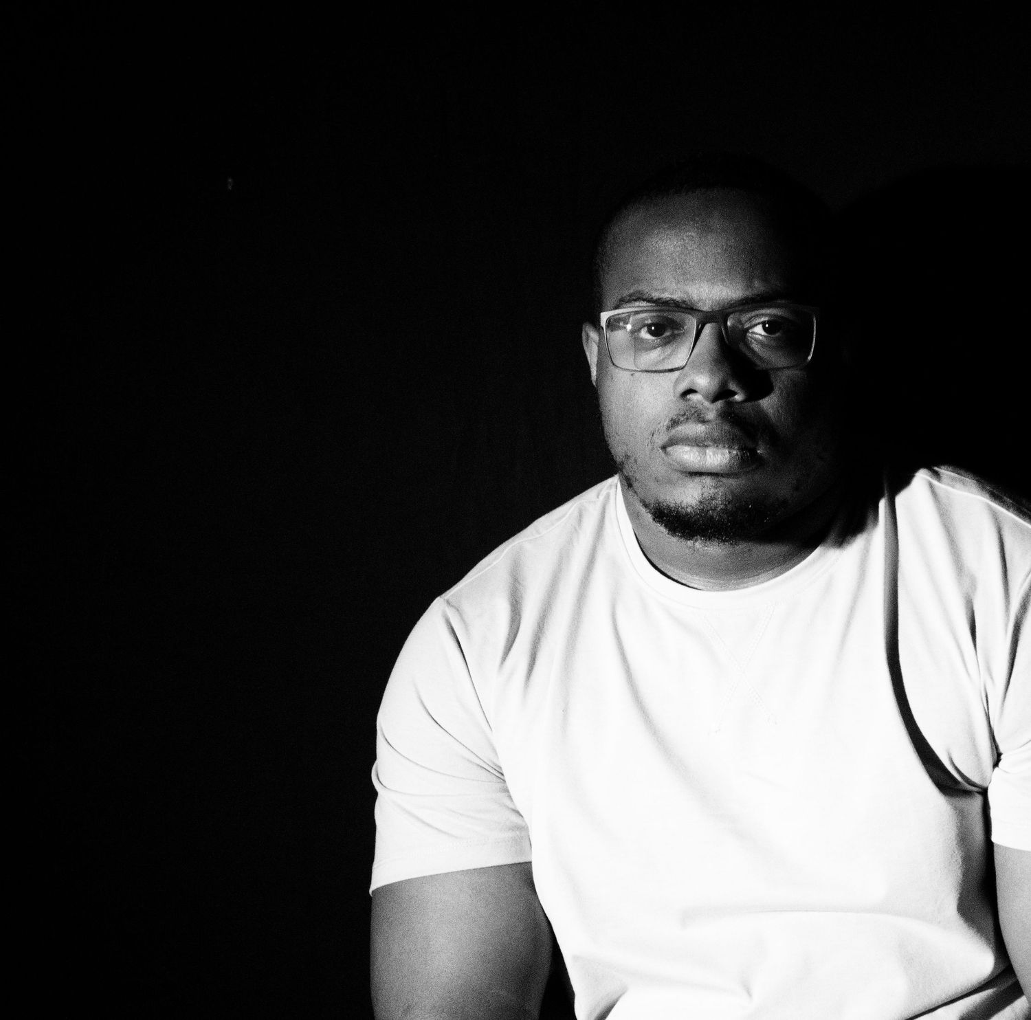 Creative black and white portrait photography utilizing dramatic split lighting and deep shadows, ideal for a fine art portrait.