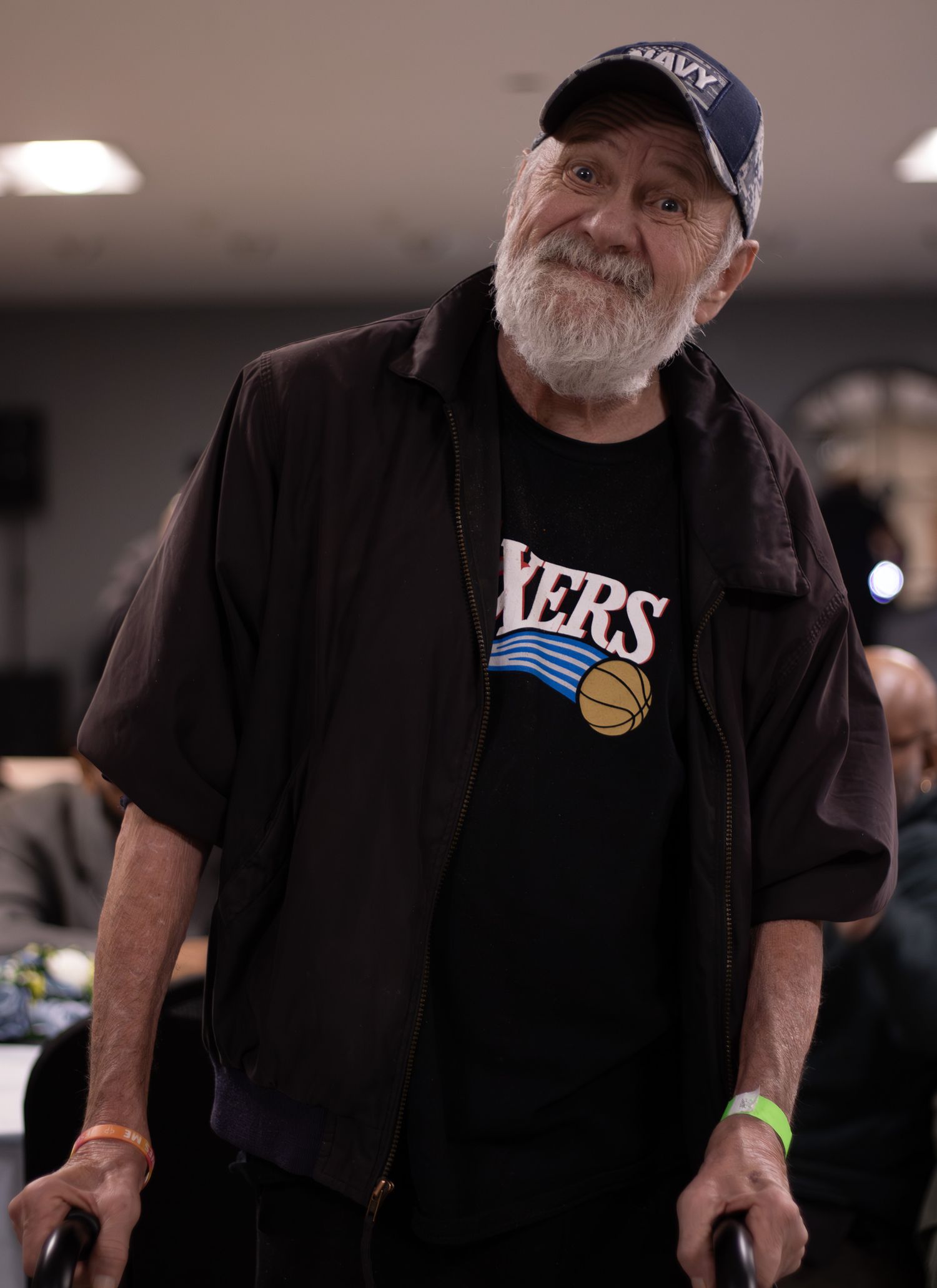 A warm, expressive indoor portrait of an older man smiling, captured by a professional photographer.