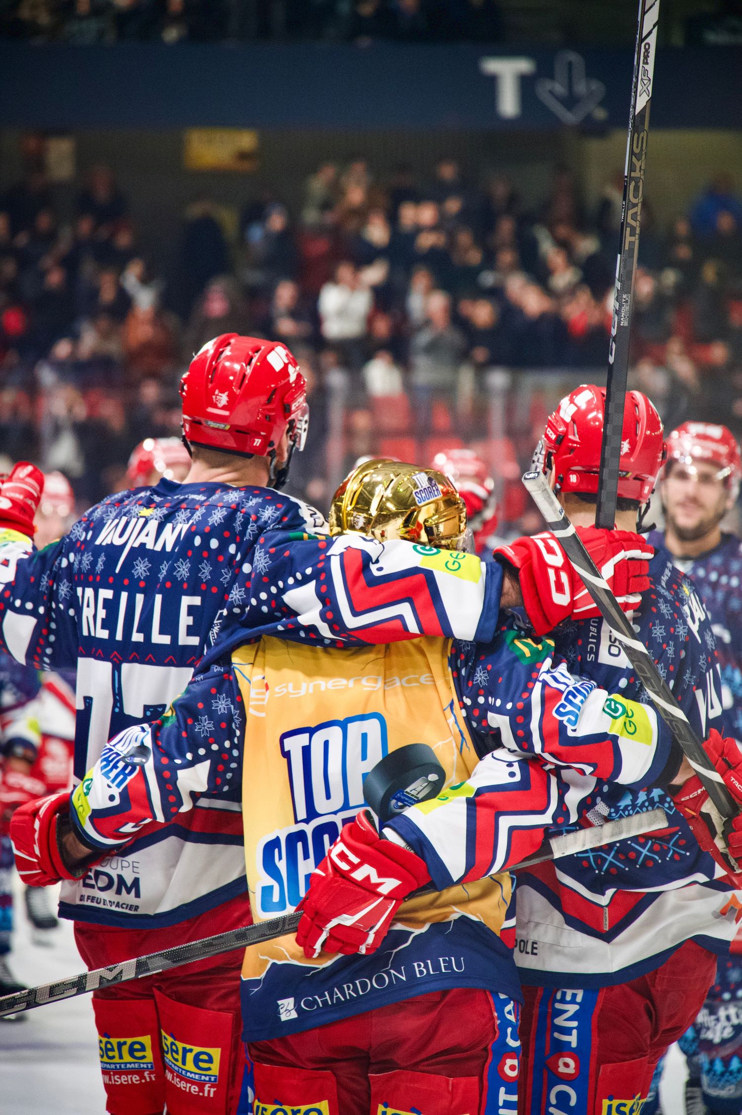 Brûleurs de Loups celebrate during a 2024–2025 Ligue Magnus match vs. Anglet, with top scorer Kyle Hardy in gold.