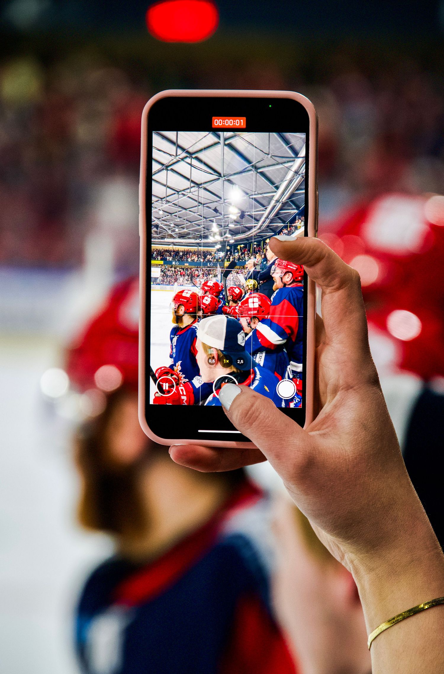 Photo of someone taking a video on their iphone of the Bruleurs du Loups bench during the 2025 Ligue Magnus final playoff game.