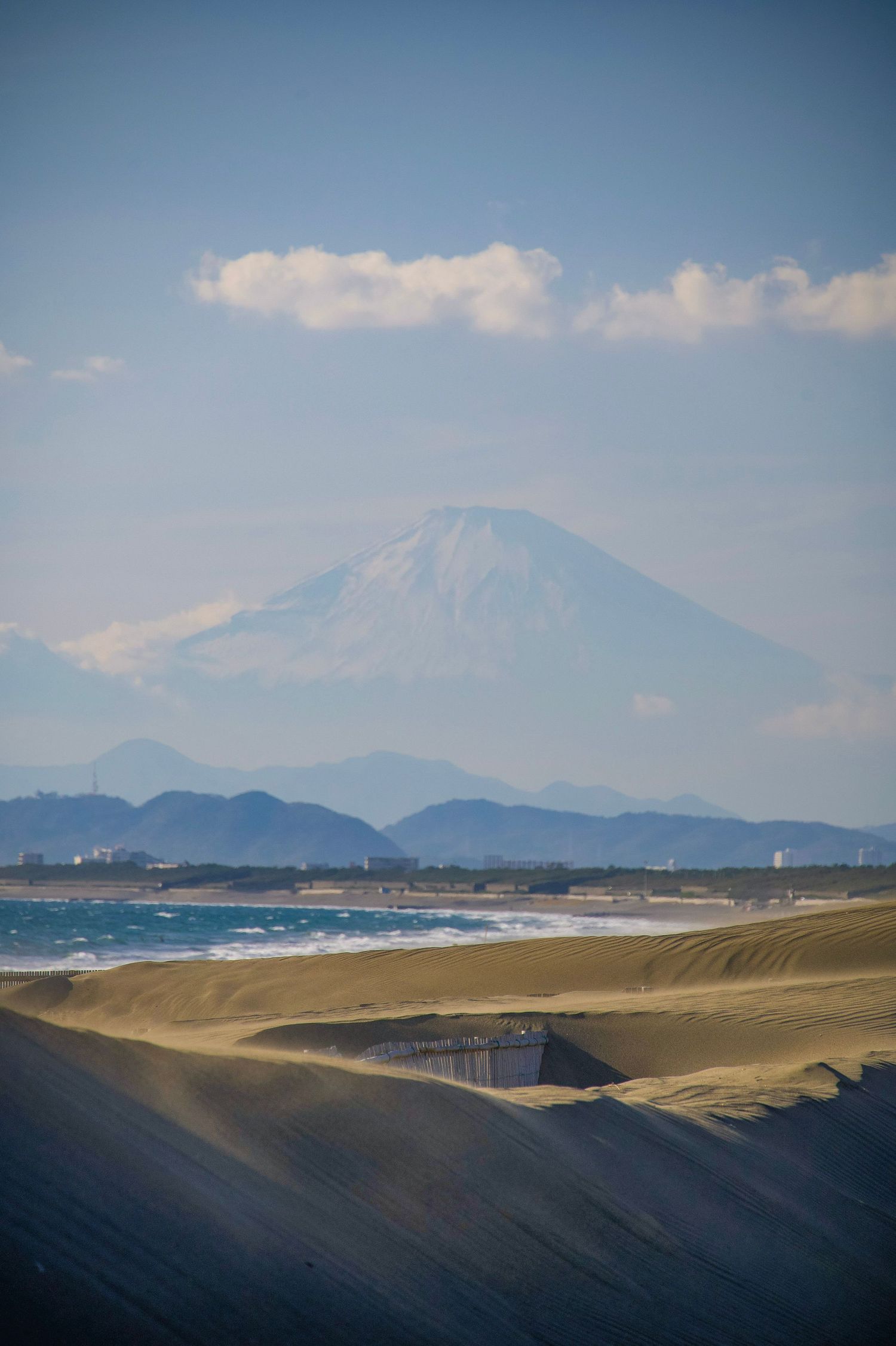Mount Fuji viewed from Enoshima in November 2025, with the ocean and coastal dunes in front.