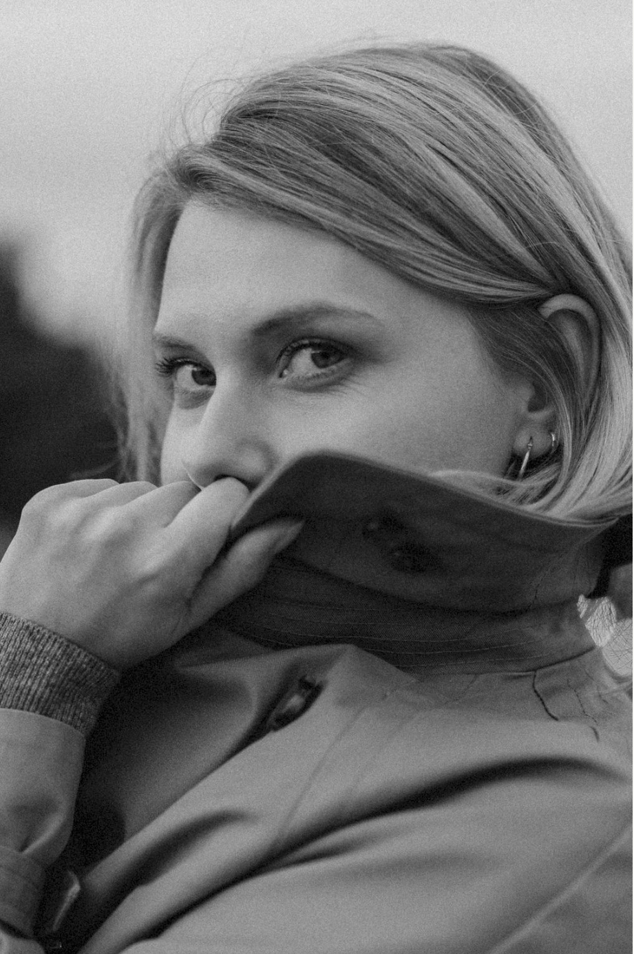 Atmospheric portrait of a woman bundled in coat and scarf during cold weather.