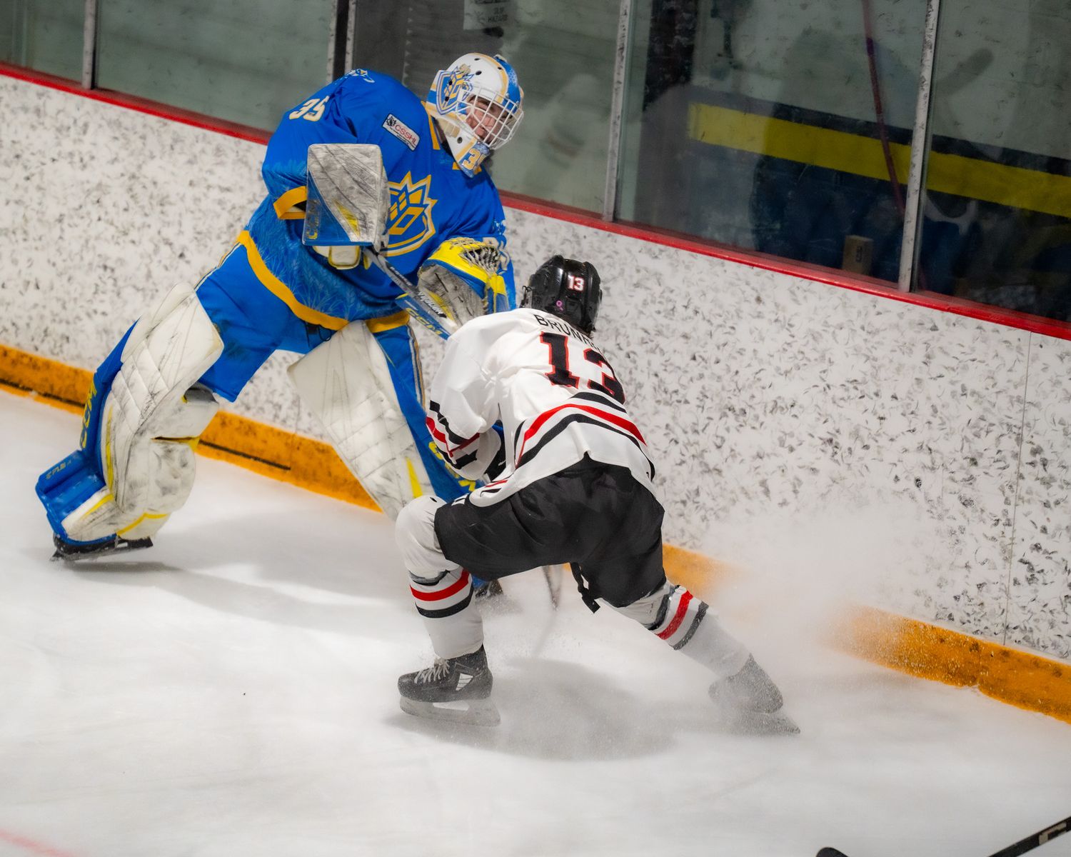 OHA forward battles for the puck with PHA goal tender.