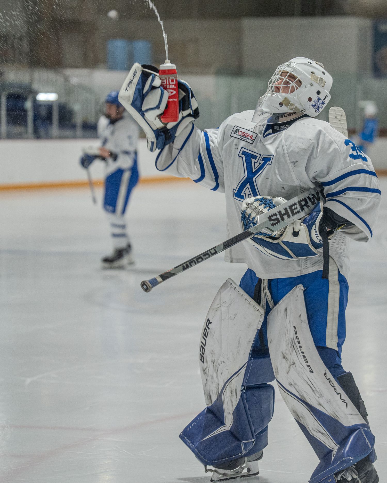 NAX U17 Prep player sends water flying from his bottle during a pause in action.
