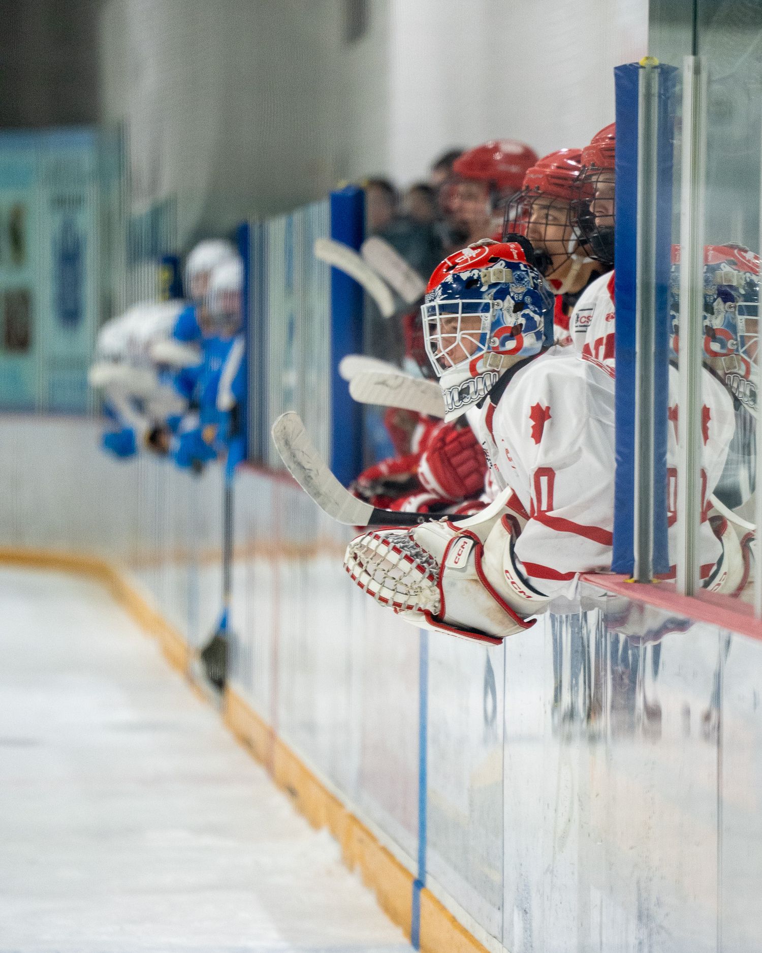 ND Hounds bench during U18 Prep action, with the backup goalie leaning over the boards.