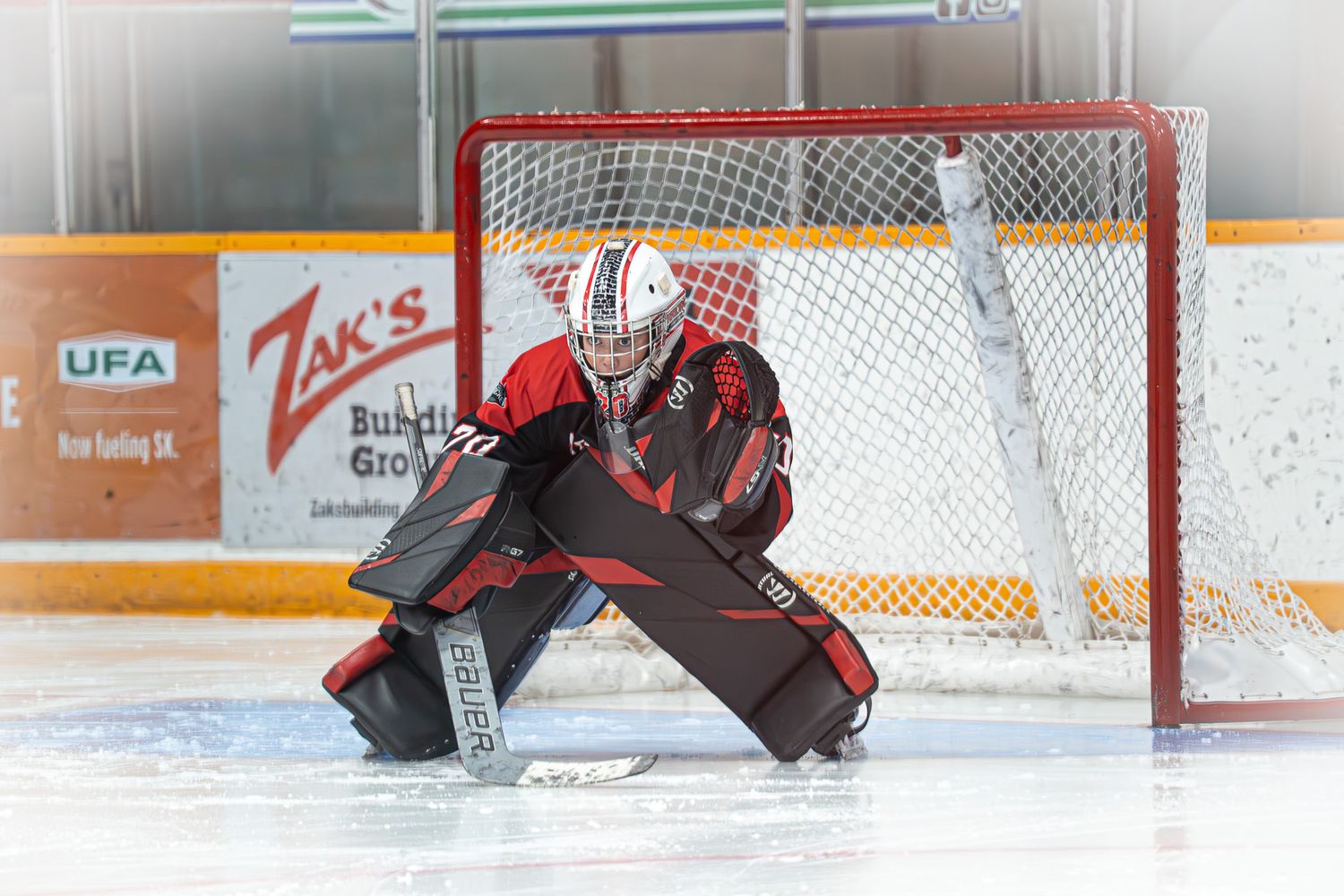 U13 AA Moose Jaw Warriors goalie set in net during game action.