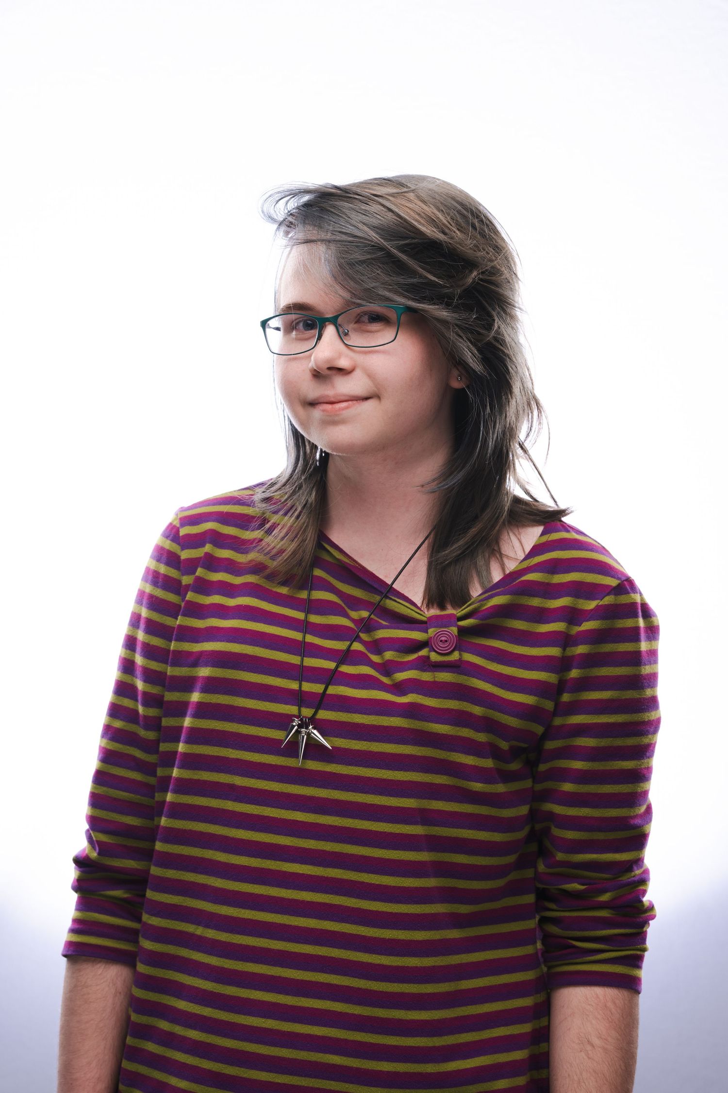 Person wearing glasses and a brown and purple striped sweater poses against white background in three similar shots.