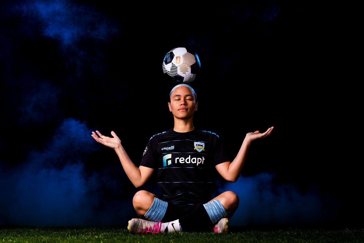Volleyball players in dark uniforms against blue lighting for dramatic sports photography.