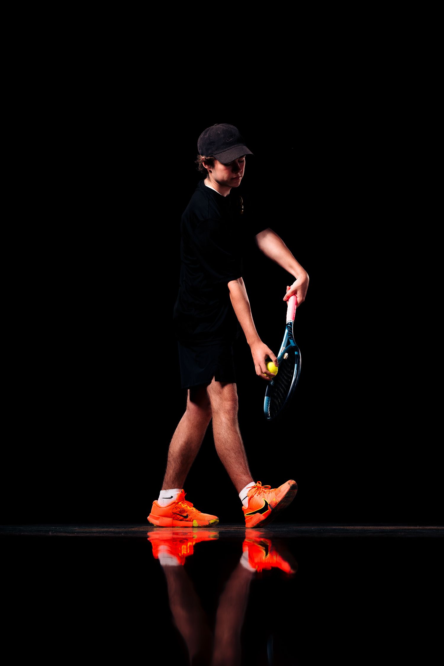 A sequence of shots showing legs wearing black shorts and bright orange sneakers against a dark background.