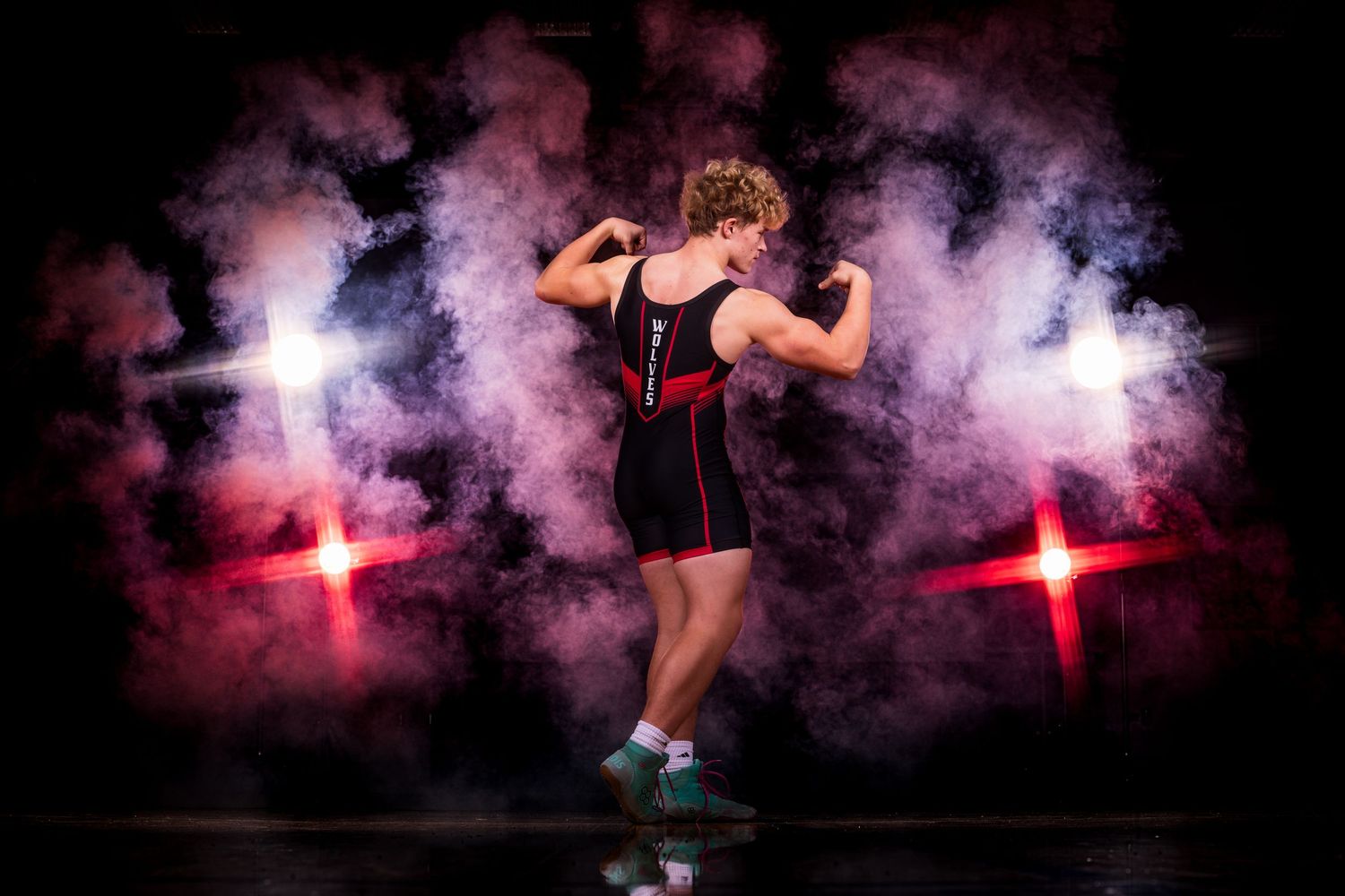 Athletic figure jumping dynamically against dramatic pink smoke and red lighting effects.
