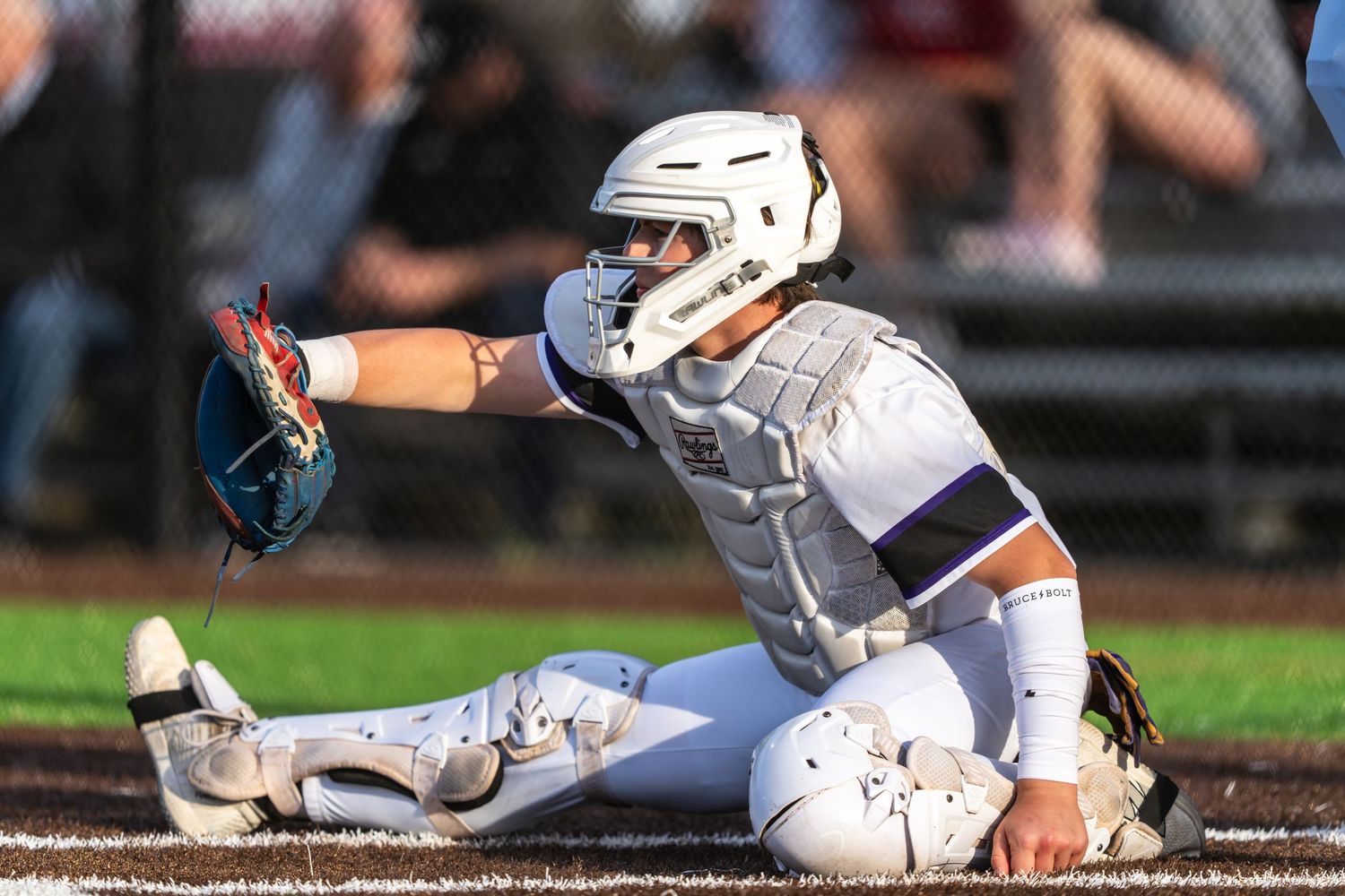Baseball player slides into base during intense game action while opponent attempts to make the tag.