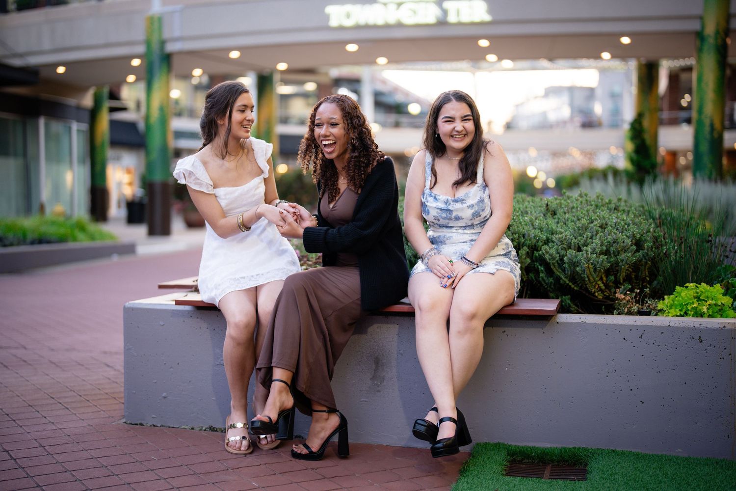 Group relaxing on outdoor benches in front of shops.
