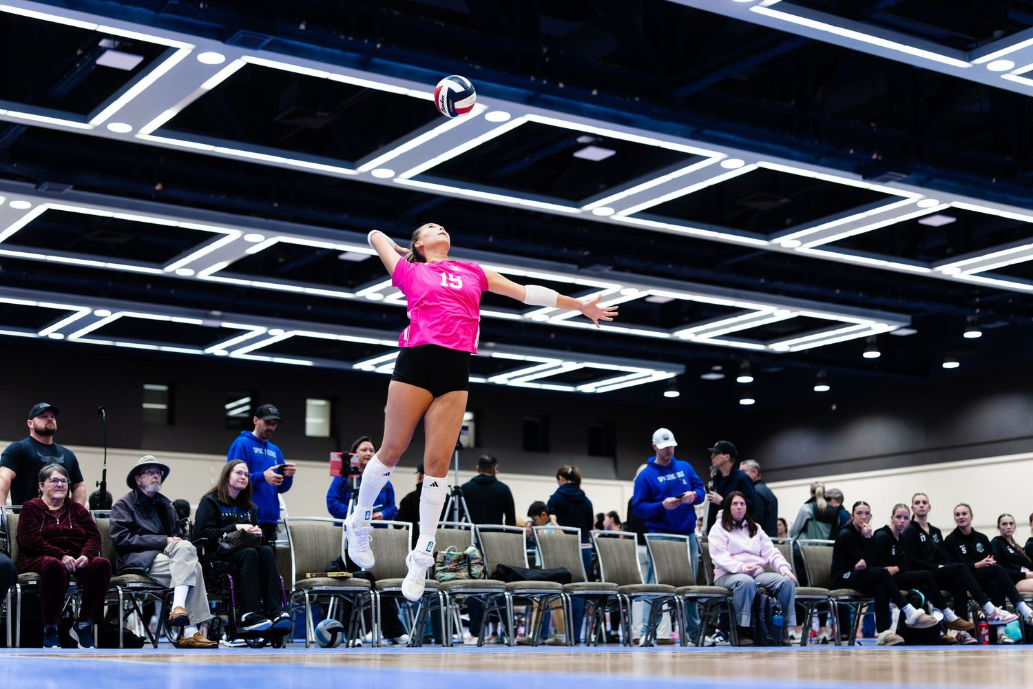 Athletes perform dynamic movements on a gym floor during an indoor training session at a fitness facility.
