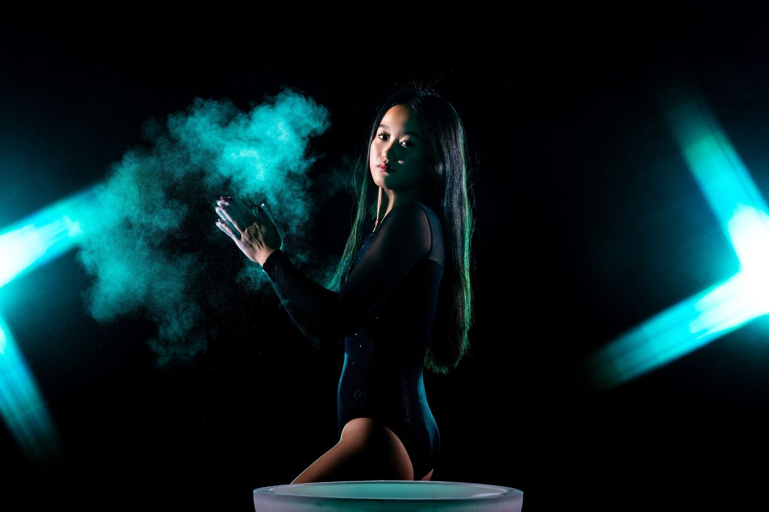Modern dance performance with teal smoke effects and dramatic lighting.