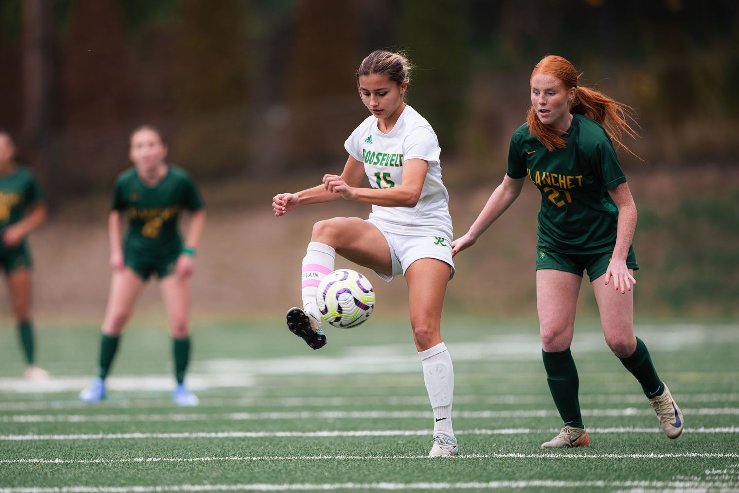 Soccer players compete for possession of the ball during an intense match between two teams.