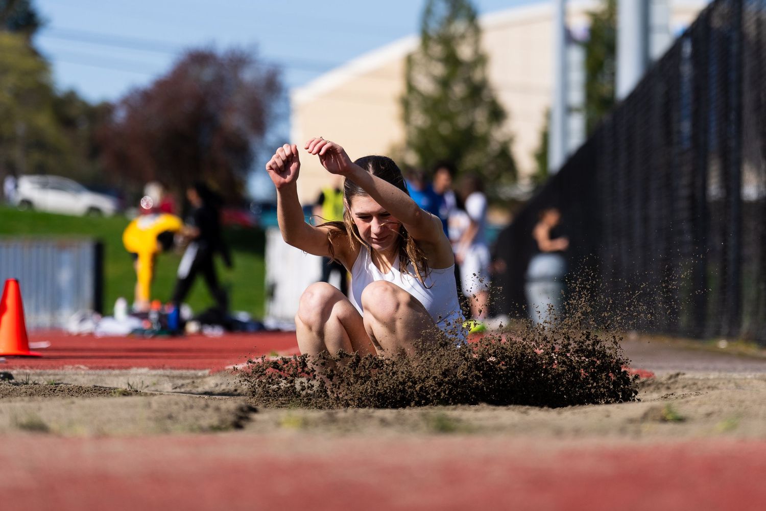 Athletes compete in long jump events at a track and field competition with sand pits visible in multiple frames.