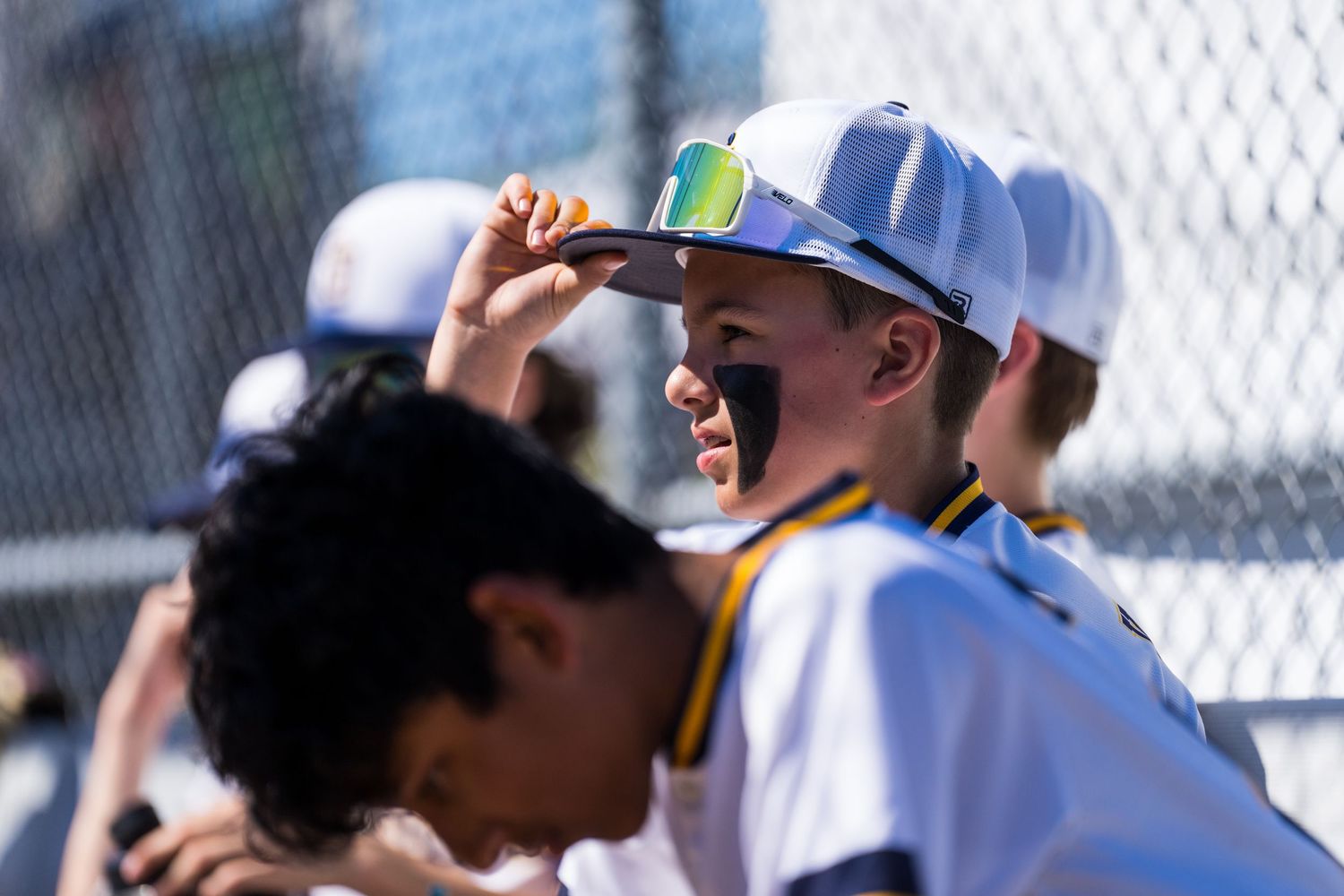 Baseball players in blue uniforms and caps gather together during a game at a baseball field.