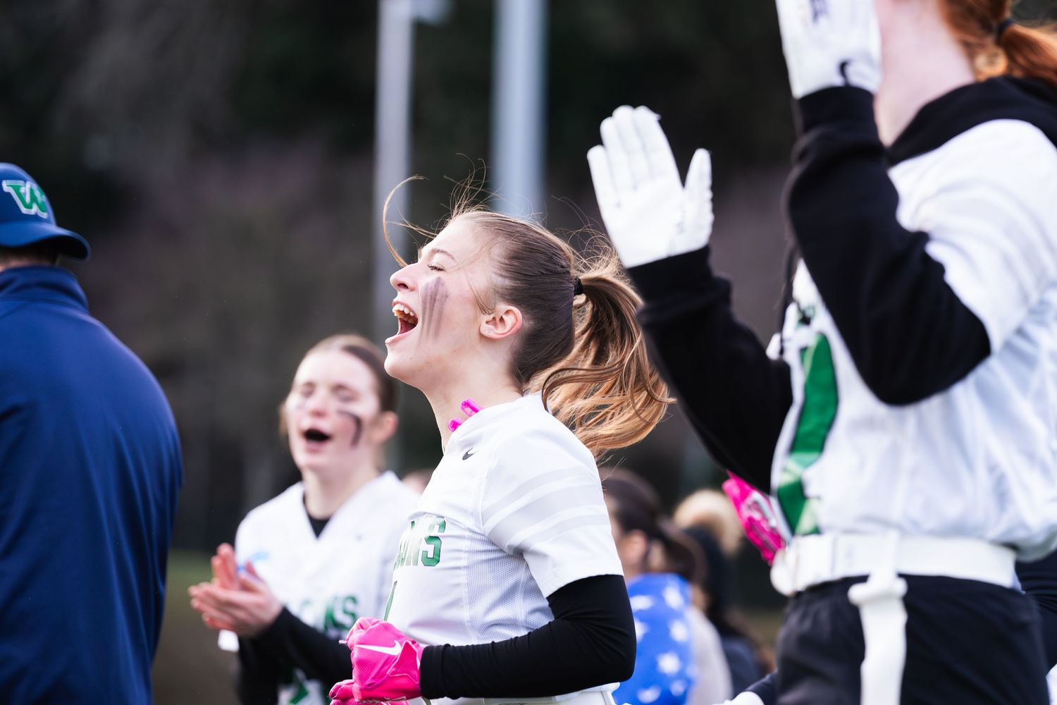 Soccer players celebrate with joy and excitement after scoring during an outdoor match.
