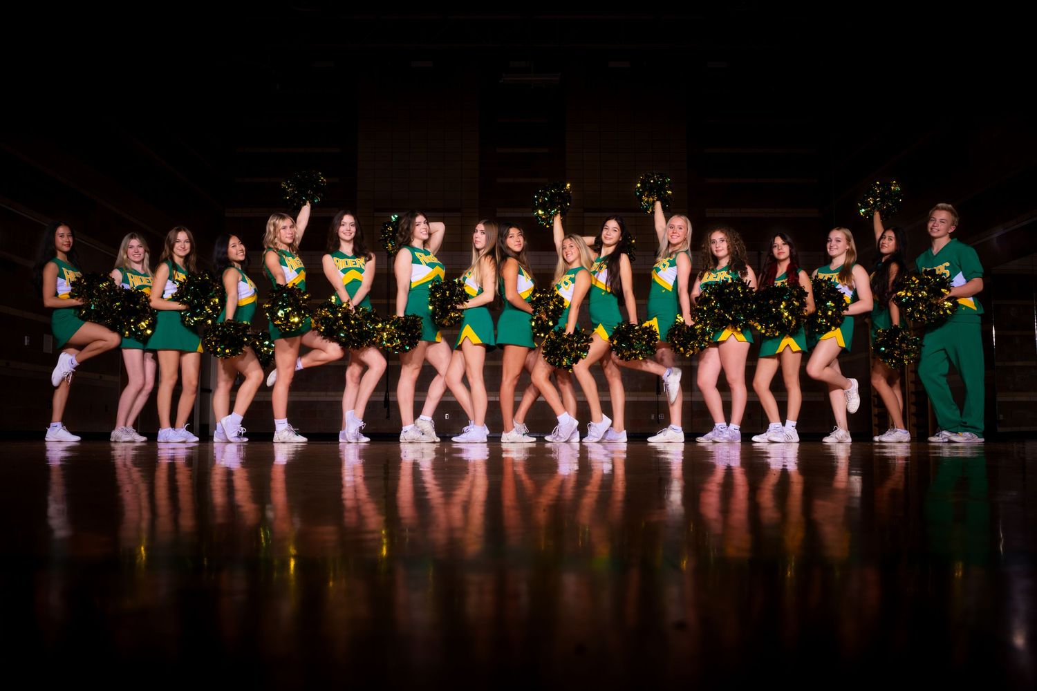 Dancers perform in a row on stage wearing matching costumes during a theatrical production.